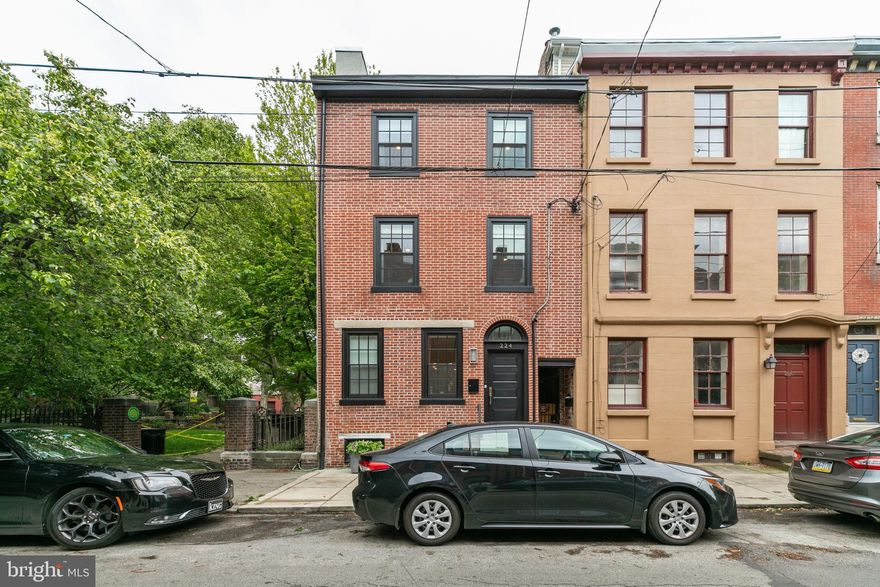 Welcome to a truly stunning residence that exudes grace and refinement in every detail. Nestled in the heart of Queen Village (within the Meredith Clymer school catchment), this fully renovated home boasts designer-inspired touches throughout and a desirable open floor plan that seamlessly connects the living room, dining room, and kitchen. Every inch of this home has been lovingly crafted with high-end finishes, including handsome solid oak floors and historically certified custom windows that adorn the restored façade. The kitchen features Viking stainless steel professional series appliances, white Carrera marble countertops with an eating area, and a six-burner gas cooktop with pot filler. The kitchen space spills out onto a charming garden patio that's perfect for dining al fresco, complete with a gas hook-up for barbequing and a wrought-iron fenced garden area to enjoy the picturesque views of Mario Lanza Park. The downstairs basement is fully finished with high ceilings, making it a flexible, multi-use space. It boasts new floors, a stunning full bath, and a cozy fireplace with exposed brick and custom built-ins. Other features include a wine center, wine cooler, hand-hammered copper wet bar, extra storage. Upstairs, discover four lovely bedrooms, including a main bedroom with beautiful vaulted ceilings, a lovely fireplace with custom woodworking, marble trim, and some exposed brick, and a huge custom-fitted California walk-in closet with shelving and custom cabinetry. The en-suite bathroom is a haven of relaxation, featuring double vanity countertops, a free-standing floating bubble soaking tub, and a shower and floor of luxurious white Carrera marble. The remaining 3 bedrooms offer generous space, an exposed brick façade fireplace, and 2 serene outdoor balconies, one of which has a charming spiral staircase that leads to a grand and impressive roof deck for all of your entertaining needs. The home's enviable location on one of the best and most sought-after blocks in Queen Village gives you easy access to a wealth of amenities, including great restaurants, coffee shops, dry cleaners, and playgrounds. This corner property also features an amazing mural named Prism which is inspired by artist Kien Nguyen’s many outings to parks and gardens around Philadelphia. The artist’s observations of shadows on leaves as the sun shines through them became the main visual element of this iconic mural. You'll also enjoy the renovation TAX ABATEMENT. Don't miss your chance to call this one-of-a-kind home yours!