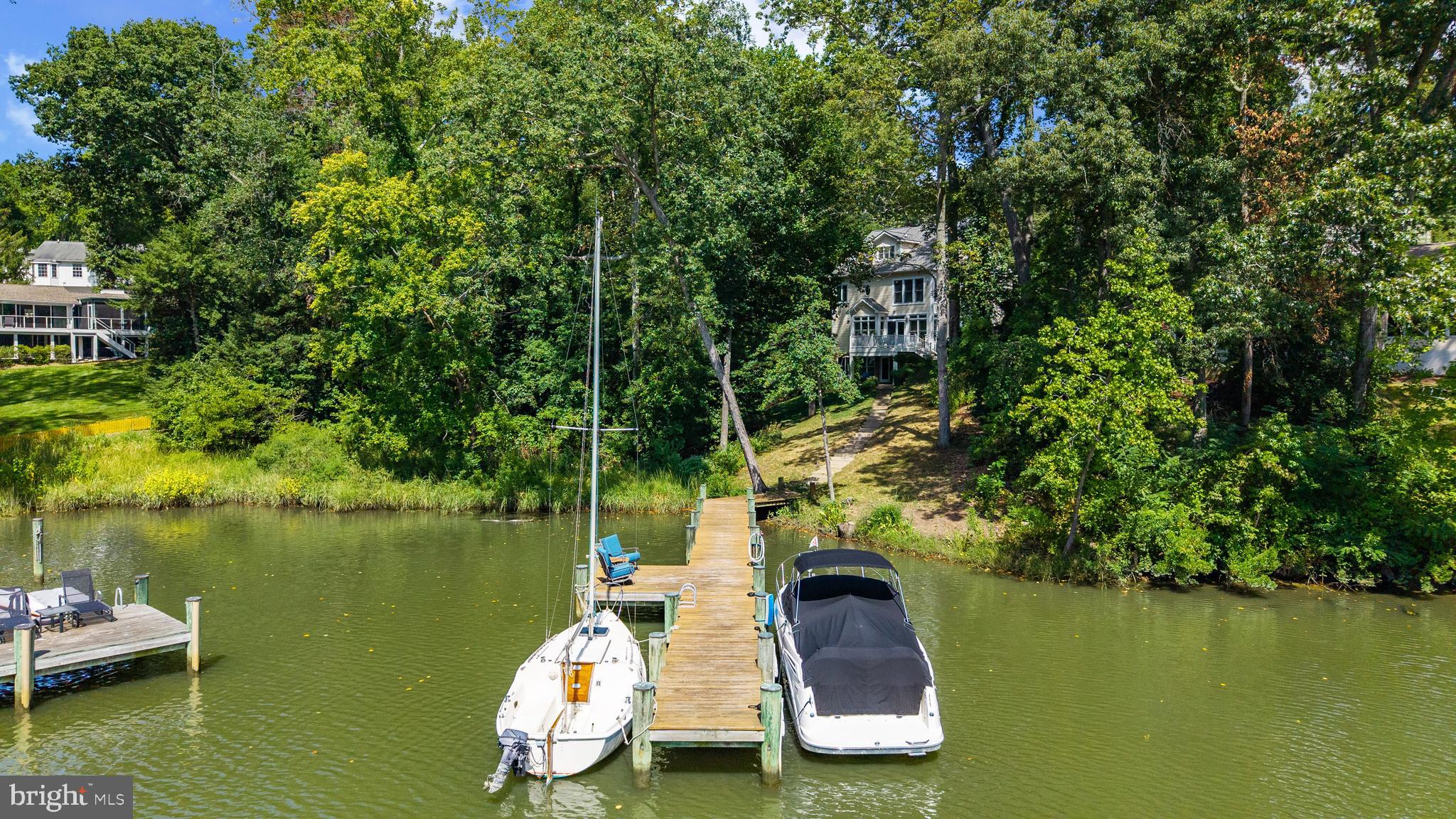 Nestled amongst the trees in the amenities rich Annapolis Roads community this 4 bedroom, 4.5 bath with 3,400 sq ft of living space has everything needed in a waterfront home! Discover the ultimate waterfront lifestyle with your own private pier on Lake Ogleton featuring 4’ MLW —providing seamless access to the Lake or out to the Chesapeake Bay for sailing, fishing, crabbing, or simply enjoying sunset cruises. Whether you’re an avid boater or just love the tranquility of the water, this property offers the best of both worlds. Inside, thoughtful details abound. The main level features a beautifully appointed kitchen and family room, enhanced with custom trim and crown molding, that opens onto a waterside deck—perfect for hosting gatherings or simply soaking in the views. Upstairs, the elegant primary suite offers water views, an elegant fireplace and a recently remodeled luxurious bath that feels like a spa retreat. Additional remodeled bathrooms throughout the home combine modern style with comfort. The versatile walk-out lower level expands your living space and could easily serve as a 5th bedroom suite, complete with full bath and wet bar—ideal for guests, multi-generational living, or casual entertaining after a day on the water. Set on a nature lover’s lot with lush plantings, the outdoor spaces invite you to relax in privacy while surrounded by beauty. Beyond your backyard, the community offers amenities that enrich the lifestyle: a Bayfront overlook with pavilion where neighbors gather, a playground, and scenic walking trails. Located just minutes from downtown Annapolis and Eastport which offers the perfect balance of small-town charm and big world sophistication. Traveling or commuting is just as convenient by easily accessing Rt. 50 and 97 which provides direct access to Baltimore, BWI, Ft. Meade/NSA and Washington, DC., or head over the Bay Bridge to the Eastern Shore for a quick beach vacation. Welcome Home!