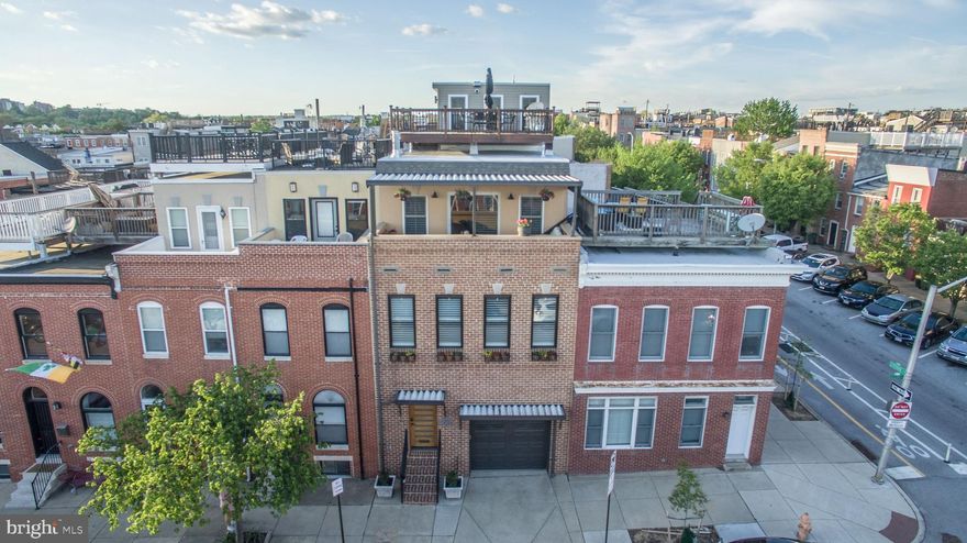 NEW IMPROVED PRICE......Not your average rowhouse! No expense has been spared in this spectacular 4063 sq. ft. Canton renovation!  Old World charm meets modern industrial chic, making this a one- of- a- kind home!  Enjoy 5 levels of pure indulgence in this unique 3 BR, 4 FB, 3 HB beauty. Three en-suite bedrooms (one with fireplace and private balcony), and 2 additional guest rooms! Large main floor kitchen/dining space with open floor plan.  Second floor family/game room with gas fireplace and entertainment bar and built-ins. Lower level flex space for office/work-out/hobby, etc. and full bath.  Contemporary Widows' Watch with half bath and additional entertainment bar leading to a magnificent rooftop and expansive panoramic city/water views! Architectural details abound throughout including custom brick accent walls, beautiful hardwoods in all but 2 rooms, skywalks, floating stairs with handcrafted steel railings (with child-proof removable covers and artistic child/pet gates), creative car lift which accommodates 2 cars in garage (and additional pad in rear).  Be sure to check out the hoist crane for easy transport of items to upper levels!  All this plus SO much more! You'll never want to leave this entertainer's delight, but if you do, just a short walk to Canton Square and all the area's finest in restaurants and shopping !