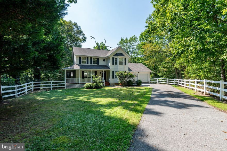Tucked away at the end of a cul-de-sac, you will love the secluded feel of this three level Colonial that backs to trees. Enjoy the covered front porch that wraps around the side of house or the multi-level decks overlooking your private and wooded backyard. Main level features a living room, formal dining room, kitchen open to family room plus breakfast room space.  Family room features wood burning fireplace for a cozy feel. Upper level has three bedrooms including primary suite with cathedral ceilings, private en suite bathroom and walk in closet. Finished basement offers plenty of space with large rec room perfect for a 4th bedroom, second living area, home gym, or entertainment space and also includes a full bath! Laundry is also found on the lower level and walk out to another level of the rear decking. Updated LVP in basement and carpet on upper level. Water and sandy beach access included and easy commute to all the local companies and base. Close to shops, restaurants and more!