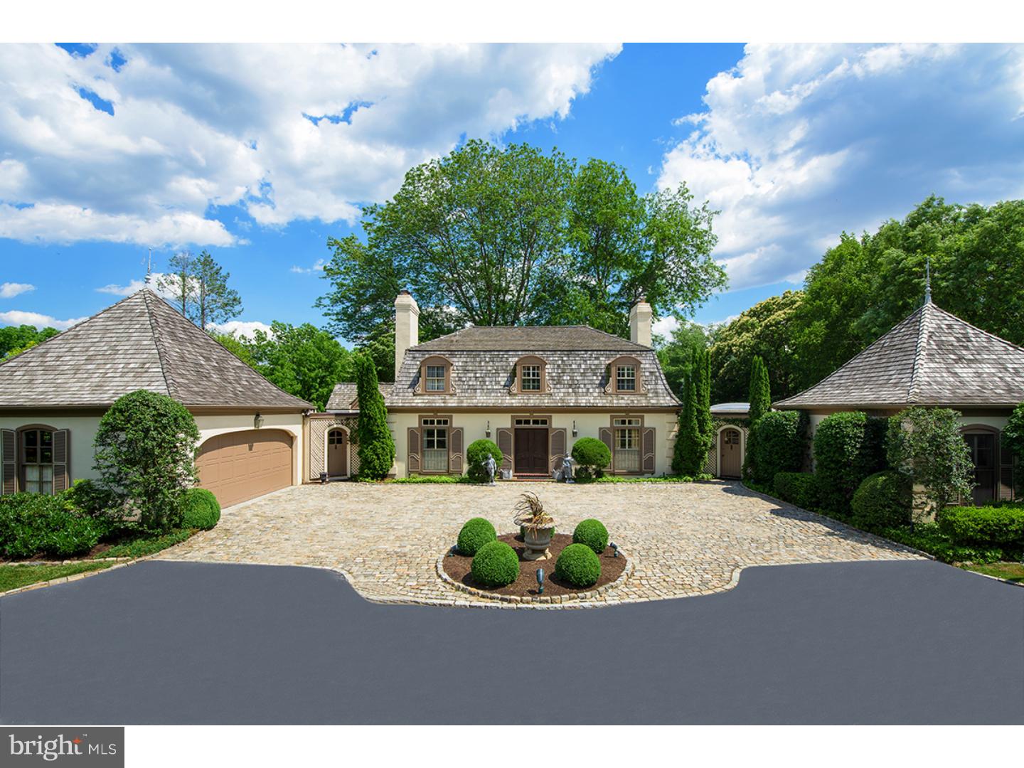 Refined, elegant with beautiful architectural balance this 5 bedroom French Mansion style home sits on a truly magnificent 2.14 acre parcel offering exceptional first floor Master Bedroom Suite and expanded, bright living space on its three finished floors. Set well off the road and accessed by a cobbled edge circular drive, arrive to stone courtyard detailed by a brick fountain and artfully crafted low stone retaining wall. Professionally landscaped for both low maintenance and superior privacy, the property boasts mature trees and deep, tiered verdant lawns. Two story inset marble entrance Foyer with sweeping wrought iron staircase sets the stage for the beautifully selected interior that follows. Formal Living Room boasts a full wall of windows and French doors which open to a wide brick Terrace spanning the length of the rear of the home. The centrally positioned marble mantle is flanked by a milled wall of character grade knotty cypress adding a warmth and appeal to this formal space . Bi-fold doors lead to the formal Dining Room with gently curved window, random width floors and deep, lit inset display cabinets. A swinging service door opens to the Kitchen and beyond to a spacious Breakfast Room with fireplace which enjoys southern views. Located off a second entrance which serves the Master Suite find a fully paneled Study with refrigeration and custom shelved bar. A brick surround fireplace with coordinating mantle is an ideal spot for entertaining or late night retreat. Currently utilizing two bedrooms and 2 full baths the Master Suite is richly appointed with a fireplace , walk in closets, and private covered outdoor patio. Ascend the stair to second level with two spacious bedrooms each with private bath which share a balcony with iron trim detailing. A finished lower level which exits to the outside offering a Bedroom and Bath, large recreation room with fireplace, shelving and large windows. Sophisticated living at its best. Garage space for 4 cars, two car attached and 2 car detached with addition storage, wine storage room with dedicated refrigeration unit.