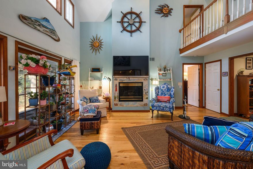 Quality and craftsmanship are the heart of 303 Tanglewood Drive tucked away in the Briarwood Estates community. With very low HOA fees, community pool, pickleball and tennis courts camaraderie and support are hallmarks of this subdivision. Located between historic Lewes and Rehoboth Beach you are one mile from Coastal Highway, all our outlets, schools, fine dining in downtown Rehoboth Beach, and only three miles to the sand!
As you pull up to 303 Tanglewood, the driveway is on the left side of the .40 acre front fenced yard perfect for your pets and kids. This three bedroom, 2.5 bath, custom built, Cape Cod is on a quiet cul-de-sac on Love Creek. The spacious entryway leads to your family/great room, where a gas fireplace serves as the focal point, creating a warm central space for gatherings. A balcony above provides easy communication with your guests/family upstairs. The thoughtfully designed kitchen features a breakfast area with an opening to the great room! The kitchen also features a butler’s pantry, modern appliances, including a dishwasher, electric oven/range, microwave, and a refrigerator/freezer, ensuring that culinary endeavors are both enjoyable and efficient. Fix drinks in the large wet bar area located between the formal dining room and the breakfast room. The spacious first floor master bedroom has a walk-in closet and ensuite bath with double vanity and soaking tub. Sliding glass doors lead you out to a screened porch with the hot tub in your very private backyard with the Love Creek view. At the end of the driveway, the 2-car garage comes with a workroom while the second floor includes two spacious bedrooms, a full bath, and a bonus room. The second floor is the second of two heating/ac zones allowing for more effective utility control. A private staircase access comes up from behind the kitchen near the interior garage door. Loads of storage upstairs and down is another functional feature of this property. 
Natural light floods through insulated windows and views of your private pier/dock. For water enthusiasts, this property is a true gem and very hard to find this close to the Atlantic Ocean with water access to Rehoboth Bay. This residence is a lifestyle. Experience the perfect blend of luxury, comfort, and nature in this exceptional property, where every detail has been thoughtfully curated to create a sanctuary, you will cherish for years to come.