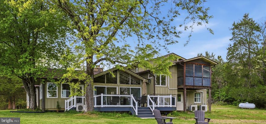 Life will be heavenly in this rustic and contemporary river bottom home on 5 acres with 150 ft. of breathtaking Shenandoah River frontage that has complete privacy and seasonal views of fertile farmland and mountains beyond.  Calmes Neck is an environmentally friendly gated community nestled in the Blue Ridge Mountains at its beginning and The Shenandoah River at its end. Calmes Neck has a 10 acre private river bottom community area with a boat landing, picnic area & boat landing. Surrounding Calmes Neck is The Burwell-Van Lennip Land Trust so all that live here can rest assured that the surrounding countryside will remain the same. As you approach the home you will head up a lush tree-lined driveway . On your way you will see through the trees a spring fed pond that is shared with the neighbor. At night one can enjoy listening to bull frogs and other night time sounds of nature.    At the top of the driveway the land will open up to an open field  overlooking the mountains and valley., There are no restrictions currently effecting this home so bring your four legged friends and enjoy fresh eggs if you like from your own chickens.  The House is 2,349 square feet. It features a 2003 addition of a lovely architecturally designed dining area that lends balance and charm to the home and withinthe last four years, a den/ office as well.. It has as its focal point many  Andersen roll-out casement windows and a beamed cathedral ceiling.  This sunny addition features views in every direction that you will never tire of.  There is a massive stone chimney in the middle of the large living room and step down family room. One side of the chimney houses a wood stove.and there is radiant hot water baseboard heaters as well as new Mini Splits. Gather the wood from your own property to help keep the home cozy.  All Combined, This highly efficient system will heat the whole house. . The  expansive Family Room has 2 sets of double doors to a large new TREX rear deck and double atrium doors to the welcoming Den/ Office that leads to a  screened in porch where one can spend hours enjoying this seasonal outdoor living space.   The stone fireplace in the living room will add an additional warm glow to the house. There is a main level primarybedroom and a full bath that have both been renovated 4 years ago with a claw foot tub that has a brass shower hoop and a two shower head tiled walkj-in shower.. This bedroom has a new double door as well as a back door to the outside for a private entrance. Upstairs is a primary bedroom & an office/guest room. The primary bedroom has a very  large walk-in closet and private bath with another renovation also completed 4 years ago. It has a vintage claw foot tub that has a brass shower hoop and a custome two bowl vanity as well as a large tiled walk-in shower.   The second primary has a  screened " Sleeping Porch " or balcony where one can enjoy some star gazing or a cool evening breeze and some star gazing.  FEATURES: Most of the house has freshly sanded gleaming hardwood floors. There are  newer windows. The interior and exterior have both been recently painted and stained. The roof is new as is the water heater, 4 year young redo of both bathrooms, the kitchen, one of the primarys and the mini splits.  The owner has also built a large oversized 2 car garage with a large storage room.  It is a rare offering in a sought after river- bottom community. This home is a well woven blend of old and new with lots of open space, beamed ceilings, many windows and  multiple doors that open out to great outdoor living spaces. You will love the woodwork cathedral ceilings and  location.  Set up your private showing today.  This home is a pleasure to show.  ENJOY!
