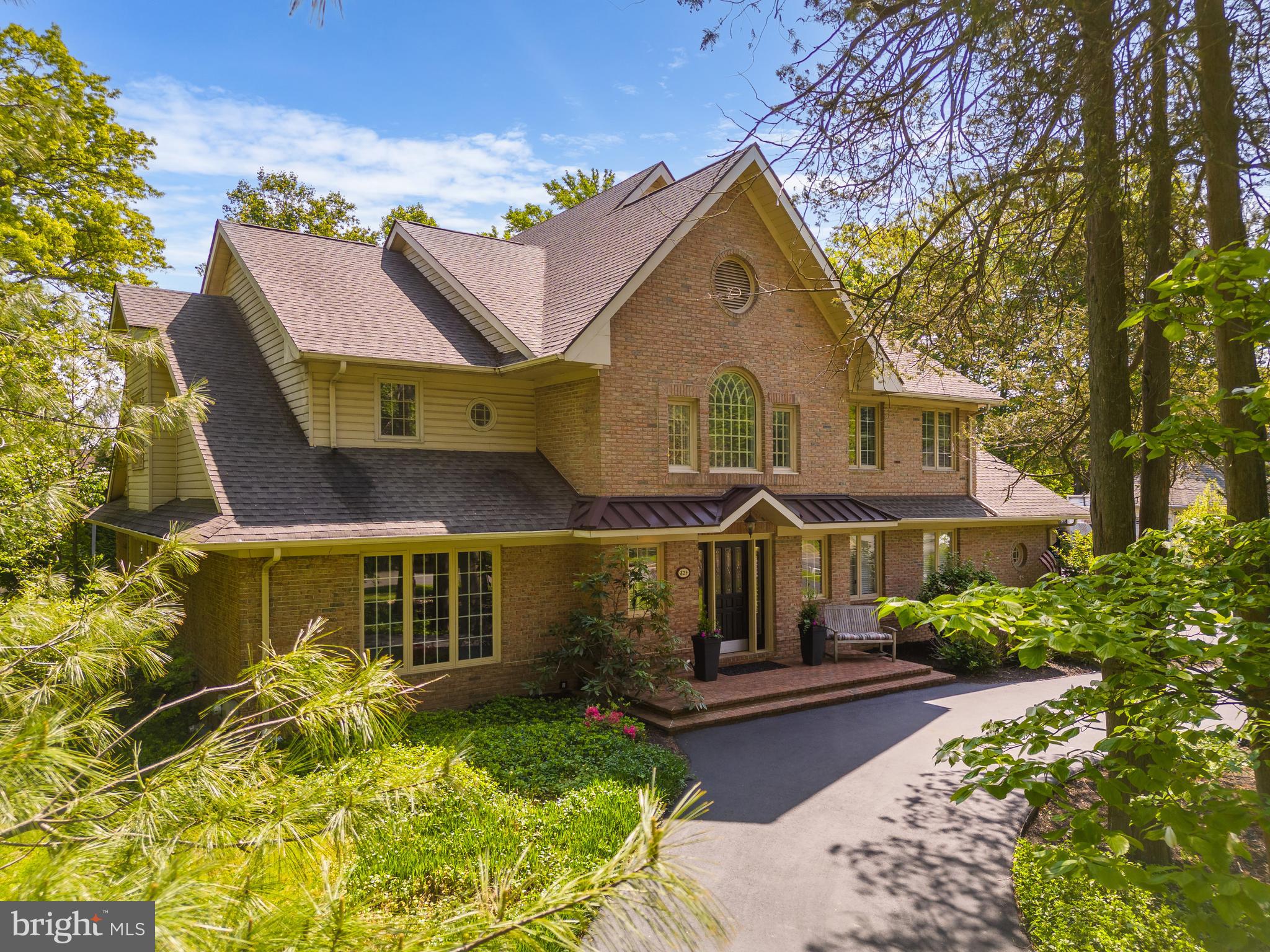 Welcome to 825 Foxwood Circle - This stately custom-built brick home is situated on a quiet cul de sac in a very desirable Whitemarsh location close to WVCC and the Wissahickon trail. This 4 BR/2 full plus 2 half bath features a floor plan which is perfect for today's modern living.
Enter the grand foyer replete with dramatic and elegant 2-story ceiling with custom moldings and millwork and new onsite finished oak hardwood floors. A formal powder room is off to the right, ideal for guests plus a convenient coat and storage closets. A private step-down large office with large windows facing the front and grass wallpaper is ideal for today's work from home lifestyle.
In the rear is the fabulous open concept living area. A true chefs eat-in kitchen completed in 2018 features Thermador and Bosch appliances, white shaker cabinetry, custom hood, contemporary quartz countertops and island complete with bar sink and ice maker. Informal den area with bar area is perfect for casual daily living or entertaining.
Center dining room area featuring a dramatic atrium style vaulted ceiling with skylights and custom built-in leads down to a gorgeous sunken living room in the rear with a gas fireplace and walls of glass overlooking the patio and pergola with white Japanese wisteria. The rear yard is private and tranquil and easy to maintain. The deck is waiting for your entertainment, grilling and outdoor gatherings.
Ascend to the elegant second floor to a central mezzanine open to the vaulted ceiling and overlooking the living floor. 4 great-size bedrooms and 2 full baths have been thoughtfully designed around the mezzanine. Primary suite oasis complete with spacious BR includes custom plantation shutters. Large en-suite complete with oversized jetted soaking tub, step-in shower, vanity and dressing area plus walk-in closet with custom built-ins. A convenient additional office space with a deck overlooking the tranquil rear yard.
The 3 great sized guest BR's all with custom closets, 1 guest BA plus great additional storage closets complete this floor.
The finished lower level is incredible additional living space including a media room with video and sound equipment plus a large game room. Unfinished basement rooms provide endless storage and a workbench for the DIY-er. Oversized 2-car garage with epoxy floor plus a convenient mud room with custom built-in cubby/cabinets/bench. Large laundry room with side-by-side washer/dryer and lots of storage plus an informal powder room.
A gorgeous home with incredible curb appeal, true quality craftsmanship in prime Lafayette Hill location just over the Chestnut Hill border with Whitemarsh Township low taxes and Blue-Ribbon Colonial School District. Easy access to Center City and major highways. A truly exceptional home for today's modern living.