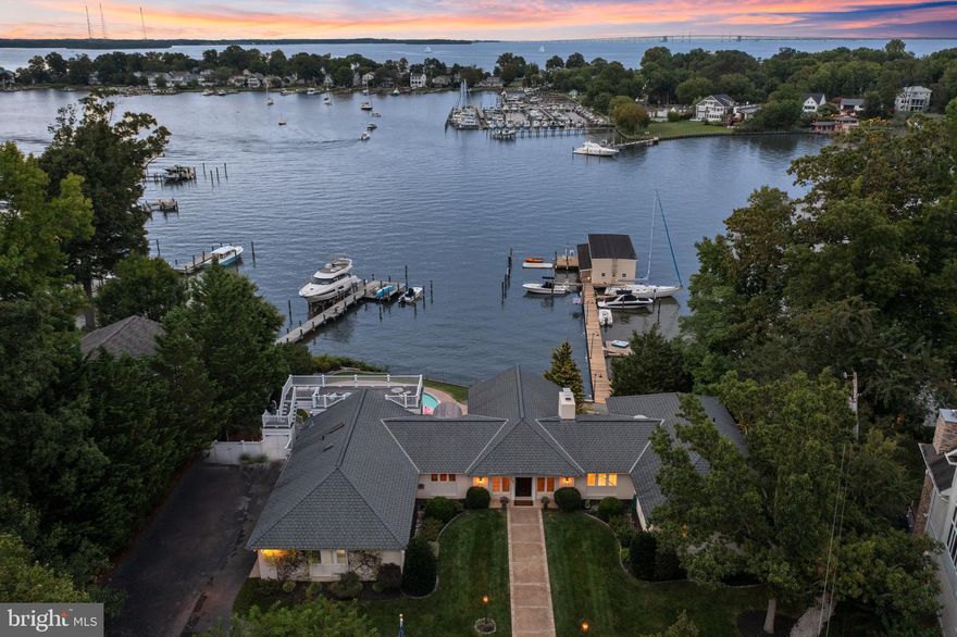 Epic waterfront property with waterside pool located in coveted Bay Ridge community. Originally the community marina location, this property boasts a 220' deep-water pier with boathouse and multiple slips on one of the largest lots in the community.  Recently refreshed with new paint and refinished floors on the main level, this 4200+ sqft brick rancher with walkout lower level is oriented to maximize the views from almost every room and the elevated lot creates endless panoramic views across Lake Ogleton. The breathtaking view through the walls of windows from the spacious sunken Living Room with fireplace and exposed beam trusses, captivates from the moment you enter the home.  The attention to detail in the arched openings and wood moldings speaks to the quality of craftmanship throughout.  The spacious dining room can accommodate large parties or a more intimate gathering and flows effortlessly to the adjacent gourmet Kitchen, Family Room and screened porch overlooking the waterside patio with in-ground pool. Crave a bird's eye view, head up to the upper deck to expand the view across the lake and glimpses of the Chesapeake Bay.  With 6 bedrooms and 4.5 baths including the spacious Primary suite with separate bathrooms, walk-in closets and private balcony overlooking the lake, everyone in the family and your guests will appreciate the comfortable accommodations. The waterside pool with expansive paver patio and outdoor shower is the perfect place to gather all summer long.  The coveted dock shack at the water's edge provides an additional hang out space for adults or kids! The sought-after Bay Ridge Community features a plethora of amenities including community pool with a clubhouse that overlooks the beautiful waters of the Bay, community beaches on both the River and the Bay and a community Marina with a newly renovated clubhouse. Off-the-water activities include enjoying the basketball court, playground, ball fields, pickleball courts, common areas and year-round community activities. Walk or ride your bike for miles along the water and enjoy all the benefits of the Bay Ridge lifestyle, there is no other place like it! Located just minutes from downtown Annapolis and Eastport which offer the perfect balance of small-town charm and big world sophistication. Traveling or commuting is just as convenient by easily accessing Rt. 50 and 97 which provides direct access to Baltimore, BWI, Ft. Meade/NSA and Washington, DC., or head over the Bay Bridge to the Eastern Shore for a quick beach vacation.