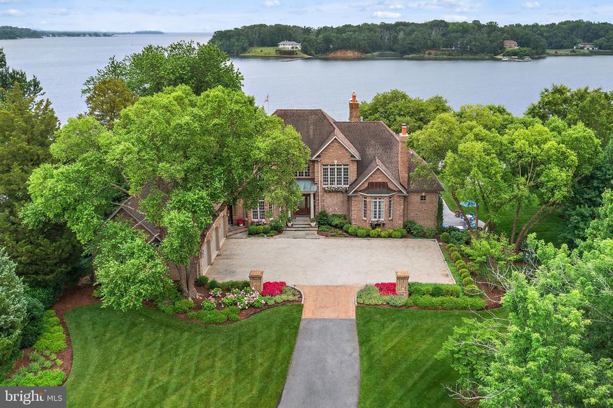 Welcome to 1556 Widows Mite Road, a stately custom brick estate gracefully situated on 1.7 acres along Glebe Bay in the prestigious Larrimore’s Point enclave of Edgewater. With over 5,000 square feet of thoughtfully designed living space, this waterfront residence blends classic elegance with modern comfort, offering sweeping views of the South River and out to the Chesapeake Bay. The home features four bedrooms and four and a half baths, including two spacious primary suites—one on the main level and one on the second floor—each appointed with a fireplace and generous closet space. The main level flows seamlessly from the formal entry into a dramatic great room with soaring ceilings and a stone surround, gas fireplace flanked by built-ins and a hidden TV. The gourmet kitchen opens to a screened porch ideal for indoor-outdoor entertaining, and both the kitchens and bathrooms were completely updated in 2020 with high-quality craftsmanship and finishes. The lower level also underwent a major renovation in 2020 and now features a custom bar, built-in cabinetry, a large cedar closet, a full bathroom with an adjacent workout room, and direct access to a newly added patio—perfect for relaxing or entertaining while enjoying the peaceful surroundings. The professionally designed landscaping, thoughtfully installed by the current owner, enhances the property's natural beauty and privacy. Additionally, an eco-friendly living shoreline—installed in partnership with the Chesapeake Bay Foundation—helps to preserve the waterfront, promote native habitat, and support long-term environmental sustainability. Enjoy resort-style living with a heated waterside pool and a gently sloping lawn that leads to a protected shoreline and a deep-water pier—ideal for boating enthusiasts. The oversized three-car garage offers ample storage. Located just minutes from Annapolis with easy access to both Washington, D.C., and Baltimore, and situated within the South River school district, this exceptional home offers a rare opportunity to enjoy private, luxury waterfront living in one of the Chesapeake Bay's most desirable settings.