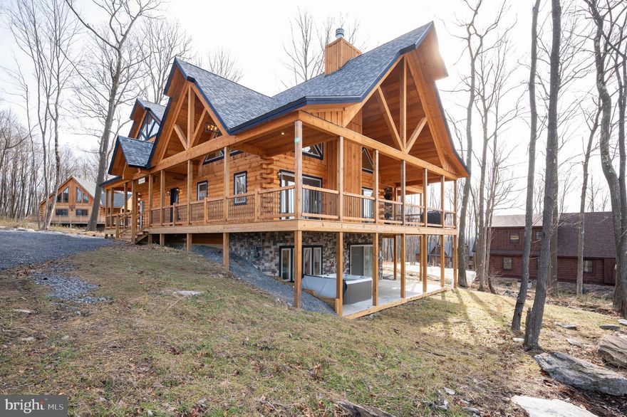 Newly completed in 2025, this stunning 5-bedroom, 5.5-bath mountain retreat blends upscale finishes with the natural beauty of Deep Creek Lake. Located in the sought-after North Camp community atop Wisp Mountain, the home offers spacious open-concept living designed for both relaxation and entertaining. Warm wood accents, soaring ceilings, and a beautiful stone fireplace create an inviting atmosphere throughout the main level. Well-appointed kitchen flows seamlessly into the main gathering areas, while multiple living spaces provide plenty of room for family and guests. After a day enjoying nearby skiing, hiking, golf, and Deep Creek Lake activities, unwind in the private hot tub or gather around the covered outdoor fireplace. Ideally situated just minutes from Wisp Resort, Deep Creek Lake, State Parks, and countless year-round recreation opportunities, this property offers the perfect balance of luxury, comfort, and adventure in the heart of Garrett County.