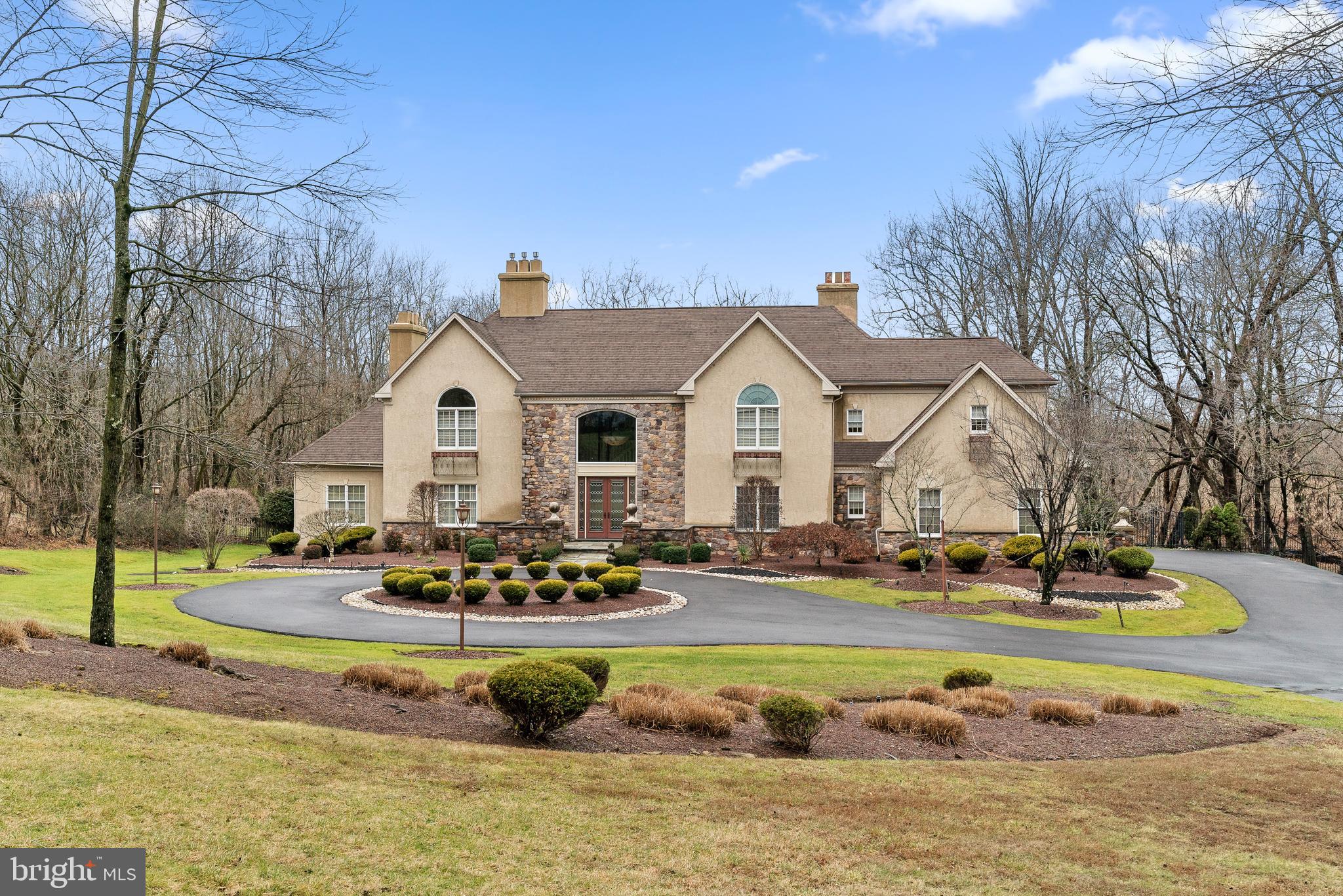 Custom built country estate situated perfectly on 4.35 acre lot in a cul-de-sac with a long private circular driveway. This home offers maximum privacy 7,400+ sqft. on three levels and is beautifully accented with the "finest of touches" Grand Foyer w/ Circular Staircase! Designed with family and gathering in mind, enjoy this open floor plan with outdoor access from each room! Two story foyer entry leads to an elegant more formal living room & dining room to the left featuring a dual sided gas fireplace with double doors leading to the all window lined conservatory. Appointed with intricate detailed moldings and custom hand paintings. To the right of the foyer is a formal powder room and gorgeous office/library with custom built-ins. The kitchen is spacious, inviting and absolutely lovely - fully equipped with all high end appliances plus open to the bright & sunny breakfast room. The grand family room is amazing - 2-story coffered ceilings, custom built in entertainment center, a gas fireplace & dual wall of windows overlooking your private in-ground pool and the Neshaminy Creek. An abundance of windows view acres of professionally grounds with a gorgeous deck including a built in hot tub & gazebo. Master suite is a true retreat complete with 2 custom fitted walk-in closets, a sitting room with balcony and fireplace, and a spectacular marble master bath. Basement is finished and complete with a cat walk to the pool, second kitchen, bar, and multiple multi purpose rooms for endless summer enjoyment.
