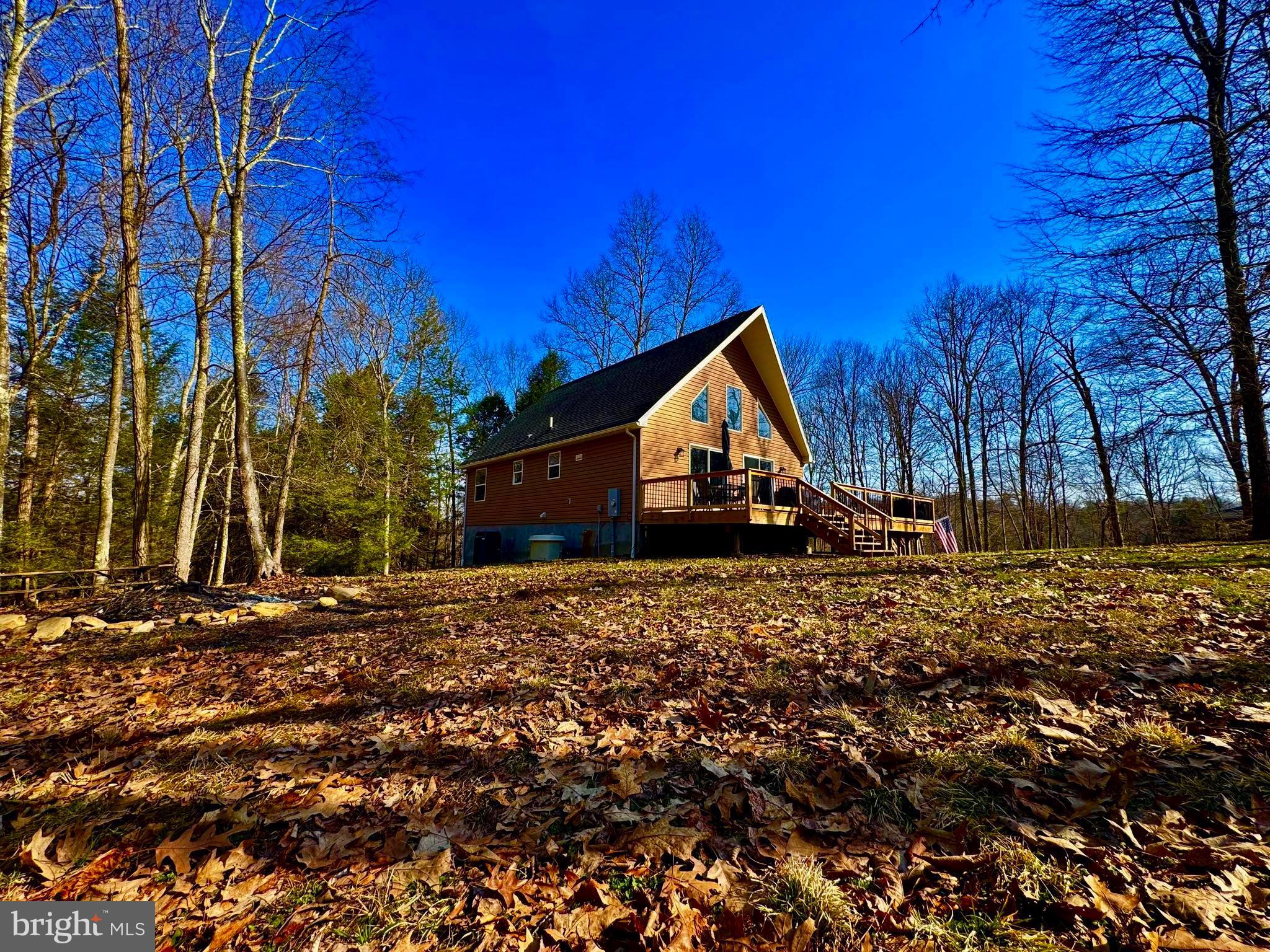 "Welcome to Wild Flower" Just 6 +/- miles from I-68 and Bruceton Mills this 1,700 +/- sqft, 3 bed/ 2 bath home on 6.28 ACRES awaits! Tucked back in the pines this property offers total solitude as you listen to Big Sandy Creek meander through the mountains. Out the front door enjoy a newly constructed 980 sqft partial wrap around deck leading into a flat, wooded front yard. This property offers riding & hiking trails, meandering creek with waterfalls, mature timber, and abundant wildlife including deer and turkey. Inside, this home features an open floor plan, floor to ceiling stone fireplace, 415 sqft loft bedroom, upgraded hardwood pine doors, and new luxury vinyl plank flooring. An expansive, 10ft ceiling, step out basement awaits finishing to your needs. For peace of mind, a full house generator provides reliable backup power for the home. Take in the sunrises with a hot cup of coffee as the spring birds chirp or share your favorite beverage with friends around your very own, private fire pit. This $250/year rural HOA includes road maintenance and snow removal for easy to and from. Additional land available. Enjoy total seclusion with just a short drive to I-68, 20 +/- miles to Cheat Lake /Morgantown, 30 +/- miles to Deep Creek Lake, 15 +/- miles to Coopers Rock State Park, 100 +/- miles to Pittsburgh, PA.