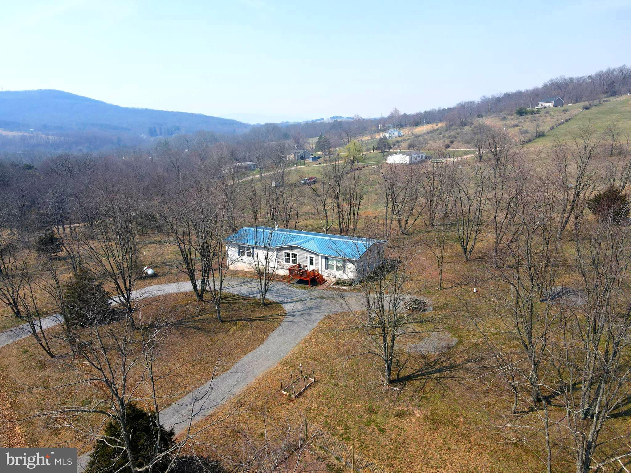 Call today to see this lovely ranch style home located on 2.5 rolling acres with majestic mountain views. The home is in very good condition with a metal roof, open floor plan and crown molding throughout. There are 3 spacious bedrooms with walk-in closets , 2 full bathrooms. , the primary bathroom having a large walk-in shower and vanity area . Spend time in the open kitchen with an island for extra prep space and all appliances iyou need to prepare meals . The lot is mostly level and has a convenient semi circular driveway. You can enjoy the scenic beauty through all 4 seasons - the lush greens in summer and spring, the white blanket of snow in winter and your own brightly colored foliage display during autumn. All located in Historic Hampshire county which is the oldest in the state. Move to West Virginia and become a Mountaineer.