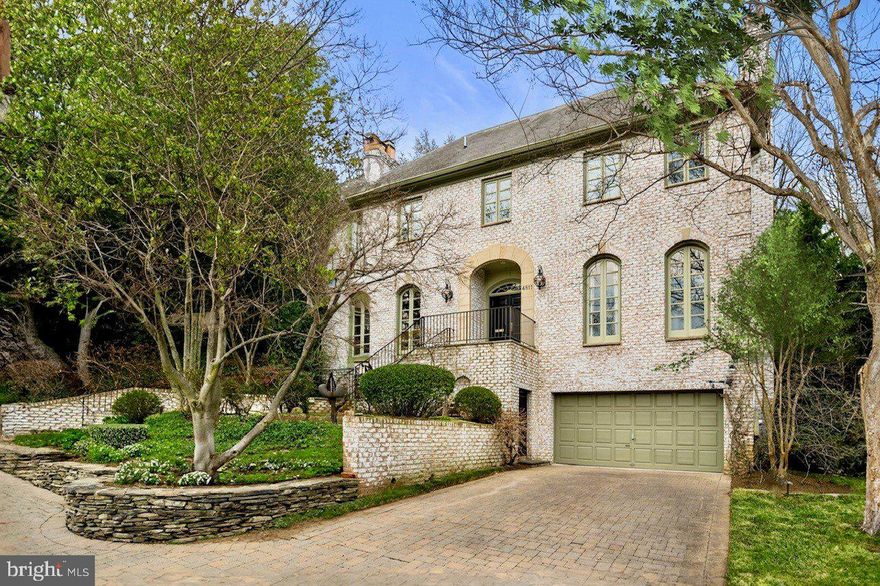 PRICE IMPROVEMENT! Design, Lifestyle and Location all converge at this very special offering. This whitewashed brick Colonial is perched high on the lot with a gracious presence. Inside, you are further struck by the interior’s flowing spaces and how they are bathed in natural light throughout. Soaring 20-ft ceilings in the entry with views to the towering 18-ft Palladian window across and in the Dining Room set the tone. As you move through the spaces seamlessly, you have uninterrupted sight lines of the gorgeous rear terrace and gardens from almost every space in the home; a wonderful backdrop for large-scale entertaining and/or cozy days at home. The Living Room, Sitting Room, Library, Chef’s Kitchen with breakfast table and at-home workspace, Dining Room, and Powder Room are located on the main level and boast architectural and design details that showcase the spaces: 10-ft ceilings, three fireplaces, five sets of dual Palladian doors, exquisite millwork throughout, banded wood floors, luxury appliances, Fornasetti tiles, contemporary lighting and window panel and doors providing indoor/outdoor experiences. 

On the bedrooms’ level, a massive skylight frames sky views. The primary suite features two separate en-suite baths (one of which was completely renovated in 2022), a large walk-in closet, a fireplace, three sets of dual Palladian doors and spans the length of the home from front to rear with three exposures; a guest suite with en-suite bath and a fireplace; a third bedroom currently used as a sitting/media room with direct access to the adjacent full hall bath; and a large laundry room. The expansive upper level is a collection of generously sized separate spaces with skylights offering a home gym, a home office, a playroom, and a huge, cedar-lined seasonal storage area. 

The lower level is partially above-grade with natural light from surrounding windows and doors, features an open multi-function space currently designated for tv-viewing/media room, a sitting room, and at-home workspace. Additional elements include a brick, temperature-controlled wine cellar, a large bedroom currently used as artist studio/workshop with direct access to the adjacent full bath and a second kitchen. Private, walk-out level access to the front of the home and interior home access to the 2-car garage, complete this level.

Your private sanctuary in the city doesn’t adequately capture the wonderful rear terrace. Mature trees and multiple, intimate gathering spaces conceal its true scale. Outfitted with an illumination scheme, flagstone surfaces, and a variety of beds and gardening areas are the added elements to your luxurious outdoor experience.

Located in Berkley, a fabulous location near MacArthur Boulevard's plethora of offerings and lifestyle amenities, with easy access to Georgetown, the Kennedy Center, Downtown DC and more.