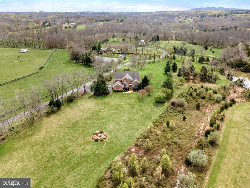 WOW!!  Talk about a  Price Improvement!  PondoRosa, a spectacular Sportsman's paradise in Leesburg!  Sited on over 50 acres on a conservancy lot in the community of Red Cedar, this beautiful home with almost 6000 sq ft sits on a perfect knoll  for views of the mountains, sunrises and sunsets, all  of which are absolutely stunning!!  This property is perfect for any level equestrian, farmer, or simply the most discerning buyer wanting the acreage AND proximity to Dulles Airport (20 minutes), Leesburg Airport(less than 10), the Greenway (10 min) and a 10 minute drive to Downtown Leesburg!  The home itself is move in ready with a giant gourmet kitchen, formal living and dining rooms, family room, den, and office as well as one full and one half bath on the main level.  The upper level boasts the primary suite with huge walk in closet and bath, three other large bedrooms and two full baths.  The lower level is perfect for the outdoorsman with a kitchen and bar, billiard room, full bedroom and bath, den with fireplace and tons of storage.    From the home, a short walk will lead you past a lovely stocked pond and around to to the classic center aisle barn.   The barn has six stalls including a wash stall, dry stall and tack room, full hay loft, and water.  Walkout to adjoining paddocks,  three additional run ins, two with water, one with water at the fence.  The Dressage riding ring measures 80 x 128, is blue stone and fenced.  Following the drive around past the  barn is the workshop which consists of  two oversized bay doors for equipment, an office which could be converted to grooms quarters, pad for RV's, and hook ups.   This incredible property also fronts Goose Creek.  Hunting, fishing, kayaking, trail rides, etc.  There is something for everyone at PondoRosa.