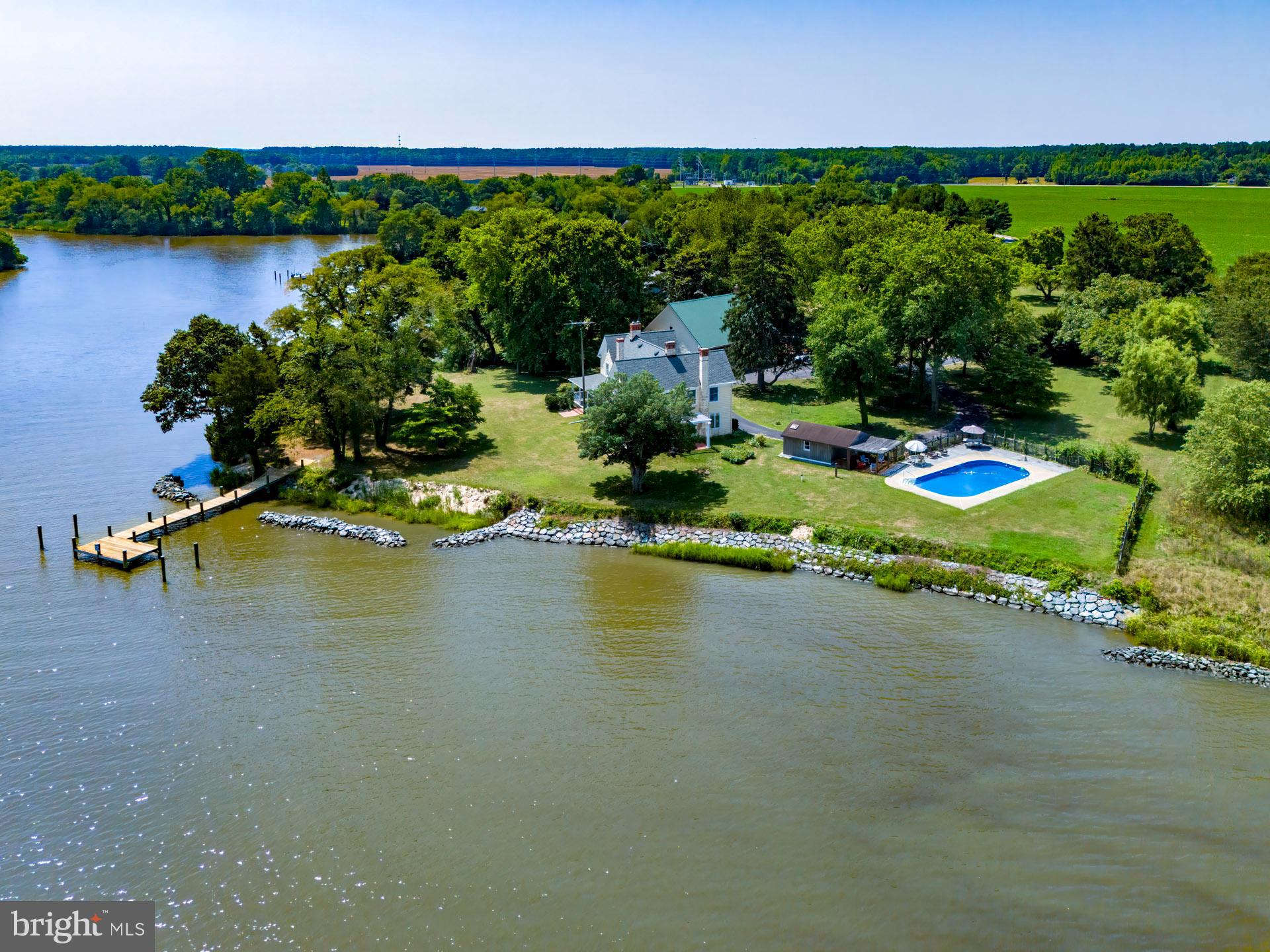 Stunning Classic Greek Revival Architecture Home on Jenkins Creek, just minutes from Downtown Cambridge. Enter the extended blacktop lane off Horns Point Rd until you arrive at the circular drive of this beautifully appointed 5 Bedroom, 4 1/2 Bath, waterfront home with water views from almost every room. The home sits on an elevated 3.3+/- acres with approximately three miles of unobstructed water views, a 60'+/- pier, and over 500’+/- of shoreline on Jenkins Creek, a tributary of the Choptank River. This meticulously maintained turn of the century waterfront home has water views from every vantage point, walnut trees, a peach orchard, and a gardening plot. Whether it's sitting around the pool or swinging on the wrap around porch, there's nothing like watching the endless flow of waterfront wildlife activity. The location of this home provides easy access, either by boat or car, to the many amenities the Shore has to offer. If you love fishing or crabbing, leave your dock and within minutes you will be in the majestic Choptank River, gateway to the Chesapeake Bay. You can put a crab pot off the dock in the early AM and possibly have dinner before nightfall. The property has an oversized five car garage with plenty of storage. The garage second floor has numerous possibilities, and is waiting for the new owners to make it their own. Many of the home’s period furnishings could be purchased separately. Come check out this unique property, we think you will love it!