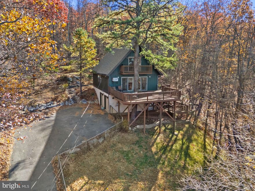 Wake up to sweeping mountain views and the peaceful rustle of the woods in this storybook chalet tucked among the trees of Shannondale. With its cedar siding, multiple decks, and warm natural light, this 3-bedroom, 2-bath home captures the very best of mountain living—quiet, scenic, and just minutes from Harpers Ferry and Charles Town.

Step inside this furnished home to an open layout and a first-floor bedroom perfect for guests or working from home. The kitchen blends maple cabinetry with Corian countertops for a simple, inviting space that opens easily to the main living area. Both bathrooms feature walk-in showers; the upstairs bath offers a skylight for natural light, while the lower-level bath includes a double vanity.

Enjoy the outdoors from every angle—two levels of decking extend from the main floor, and the upstairs bedroom opens to its own private balcony overlooking the wooded hillside. The fenced yard is perfect for pets to explore, and the two-car garage adds convenience and storage.

Backing directly to the Appalachian Trail, this home places adventure right outside your door. Spend your weekends kayaking or fishing at nearby Shannondale Lake, or gather with neighbors at the private clubhouse overlooking the water.

Whether you’re looking for a peaceful year-round residence, a vacation retreat, or an excellent Airbnb opportunity, this mountain hideaway invites you to slow down, breathe deeply, and enjoy the serenity of nature—all within easy reach of Jefferson County’s most beloved outdoor destinations.