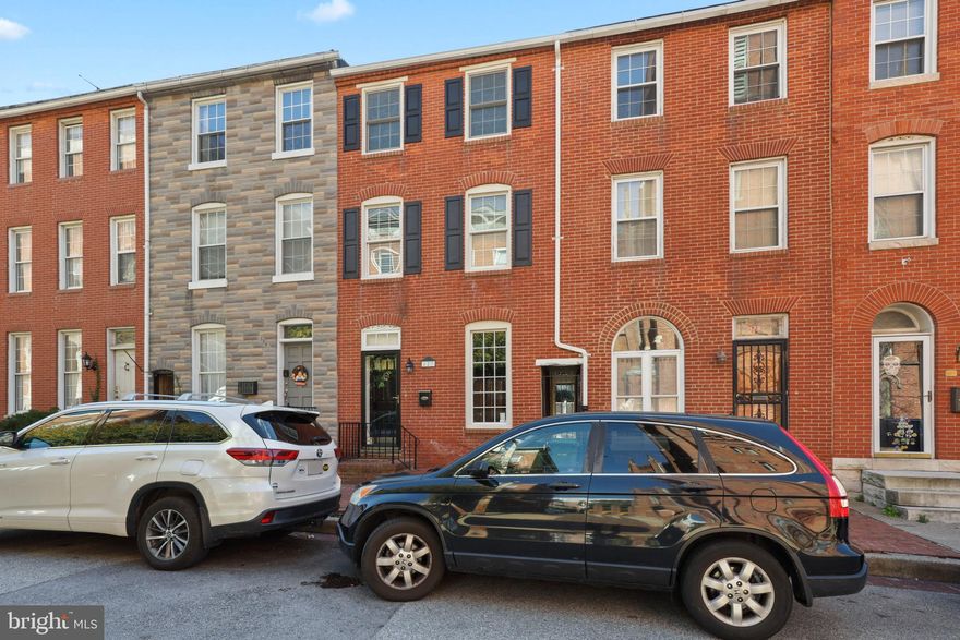 What a terrific find in Federal Hill! Gorgeous original hardwood floors are found throughout this large home with over 2000 square feet of living space. The formal living room has recessed lights, a beautiful brick decorative fireplace and built-in bookshelves.  The generously sized family room is accented by an exposed brick wall and easily fits comfortable furniture and an entertainment center. The spacious separate dining room  is painted in a pleasing tone and features a beautiful chandelier. The fully updated kitchen has solid modern wood cabinetry, stainless appliances, gas stove and granite counters and leads to an adorable brick patio. Brand new oak stairs lead the way to the sunlit 2nd floor . The front bedroom features a separate office, workout space or dressing room with plenty of closets. The updated bath includes a tiled walk-in shower and solid surface vanity. The back bedroom has a large closet and provides access to a sunny deck. The third floor is the location of the primary bedroom which also includes a secondary room for swing space and a bath with a deep claw-foot tub. Closet space is abundant! The lower level has been waterproofed with a French drain and sump pump and is fantastic for storage. The roof is new with a transferable 50 year warranty. Located in a prime location, this home will not last so come see today!