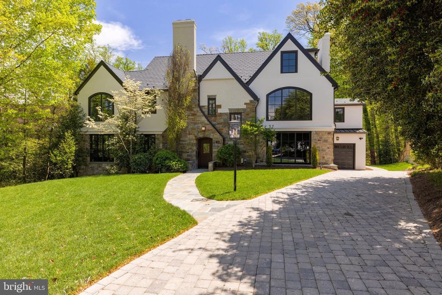 Nestled at the end of a rare cul-de-sac in Wesley Heights, this fully reimagined 1933 English Tudor blends timeless architecture and historic charm with modern sophistication. Completely renovated and expanded  in 2024 by renowned builder Chryssa Wolfe and Ella Scott Design, this 7 Bedroom, 7 Full Bath, and 2 Half Bath residence offers approximately 11,400 SF of extraordinary living spaces across four levels, which are serviced by an elevator. The Main Level features a grand Foyer that opens to a Gallery and formal Living Room adorned with a gas fireplace. Perfectly suited for entertaining, the Main Level also presents a formal Dining Room, a Gourmet Kitchen with a butler’s pantry, and a connecting Family Room that opens to a screened Porch. A Mudroom, Laundry Room, and 2 Powder Rooms provide functional convenience, while multiple access points lead to the rear Terrace, where an infinity pool and pergola create an outdoor oasis overlooking complete privacy created by a forested backdrop. The Mudroom connects to an oversized garage, completing this level’s offerings. The Second Level is anchored by a luxurious Primary Suite with a spa-like bath and walk-in closet and extraordinary wooded vistas. Three additional ensuite Bedrooms and an Office complete this level, offering ample space for relaxation and productivity. The Third Level features two additional Bedrooms, a shared hall Bath, a versatile Bonus Room, and attic/utility space for storage, making it ideal for guests or extended family. The Lower Level is a haven for recreation and wellness, with a sprawling multifunctional room, 7th Bedroom, 2 full bathrooms, a 2nd Laundry Room, and a large Exercise Suite  with outdoor access. A dedicated Spa area with a 16-person jacuzzi, cold plunge, and sauna invites ultimate relaxation and pampering. Additional storage and utility spaces, including an outdoor-accessible crawl space, enhance the residences’ functionality. Located in the coveted Wesley Heights neighborhood, this estate offers a serene retreat minutes from the area’s finest dining, schools, and parks. Zoned for Mann ES, Hardy MS, and Jackson-Reed HS.