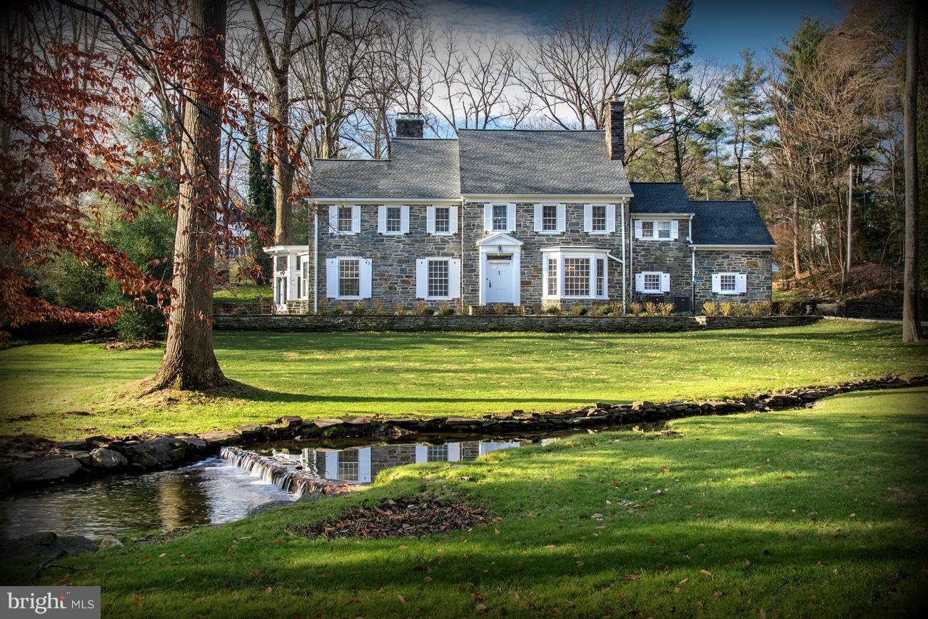 Distinctive, 4....plus bedroom stone colonial offers a center hall floor plan with elegant staircase, guest coat closet, marble guest bathroom & a wonderful great room addition. Magnificent gardens, stone terraces & an enchanting meandering creek with small waterfall & a stone bridge creating a private, tranquil, neighborhood setting on an over 1+/- acre. The step-down Living room offers 10 ft ceilings, beautiful fireplace & connects to the Great room which opens to an expansive stone terrace wrapping from the front to the rear yard & opens to the cozy den with built-in desk, cabinetry & fireplace. The elegant formal Dining room with wide cased opening from the foyer & a bay window which bathes this room in natural light & provides views of the front walk, garden & stream offers entry to the new & gleaming kitchen, featuring large island, double stainless refrigerator/freezer, undercounter refrigerator, abundant cabinetry, quartz countertops, gorgeous marble backsplash & a commercial La Cornue range. The 2nd floor offers 4 spacious bathrooms, three of which are en-suite, plus the 4th bedroom with a hall bath. 3rd floor boasts a large game room, office area, cedar closet, loft & playroom. The lower level reached from the center hall, offers game/media room, fireplace & a spacious laundry. The 2 car garage opens to a mudroom with door to rear yard & to the rear stairway leading to 2nd floor. Recently updated in a truly premium location, this special home is ideal for the discriminating buyer wishing privacy, a most convenient location & the best of Main Line Living!