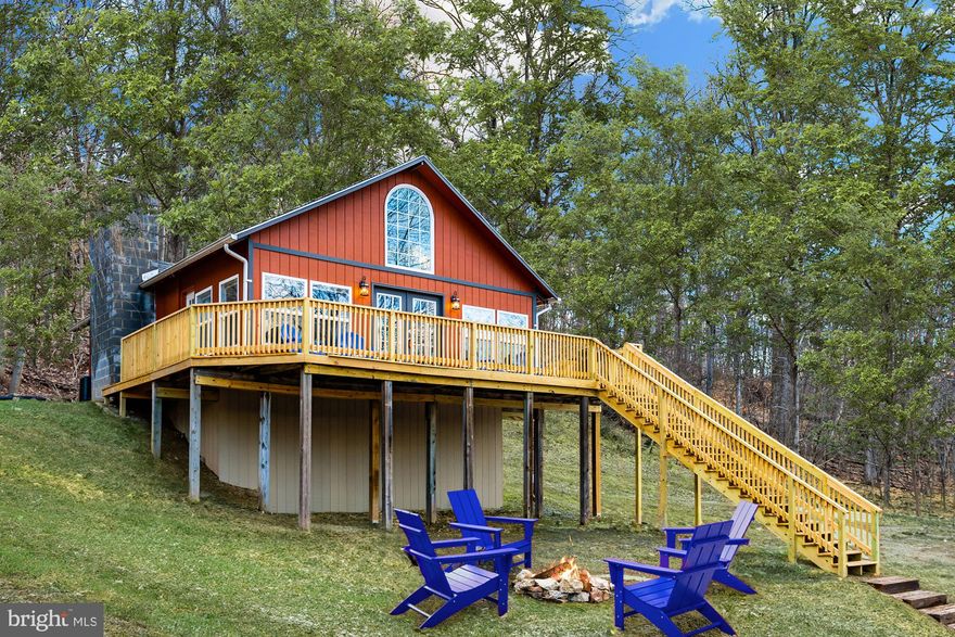 Completely renovated, chalet-style loft cabin with a huge wraparound deck!  Large windows with tall ceilings, all hardwood floors, and an updated kitchen featuring stainless steel appliances.  Two bedrooms on the main floor, plus a loft area offering a flexible space for a home office or another bedroom.  Outside you’ll find a large deck, spacious yard, and a brand new hot tub.  The cabin is located in the Sleepy Hollow community, with access to a small private lake and beach – and only about 20 minutes from downtown Berkeley Springs.  As a vacation rental, it generates about $24,000 in rental income each year (over $100k total since the seller bought it), and can come with an existing property manager and cleaner.  Hot tub and furniture optional, available for purchase.  See seller docs for a summary of rental history and financials.  $1,000 buyer credit if you continue using the same property manager.  Perfect vacation home!