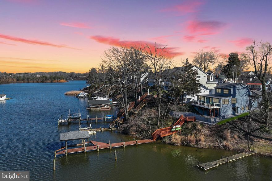 305 Cove Road is a beautifully remodeled 3-bedroom home that has the feel of living on a yacht, with wrap-around water views and amazing sunsets. Relax on the spacious deck or set out from the private, multi-slip pier to boat on the South River or out to the Chesapeake Bay. The main level features a great room with new kitchen and walls of windows. There is a separate dining room or enjoy casual meals at the breakfast bar. The main level primary bedroom suite offers lovely water views, a myriad of custom closets, and a gorgeous ensuite bathroom with separate sinks, heated floor & towel rack, and oversized shower. There’s also a powder room/laundry on this floor as well as an office with water views. Upstairs the owners have created a luxurious guest suite with two water view bedrooms, a delightful bathroom, and a coffee bar. There is ample room for a second work area or lounge space for family and guests.
There is a detached one-car garage and room for 4 cars in the driveway. There is also an unfinished basement that provides tons more storage, and houses the hot water heater. Most importantly, the owners have done all the improvements for you: new structural supports; new roof, siding, fascia, soffit and gutters; re-engineered deck and steps to water; new water heater, windows, all exterior doors, HVAC, flooring, insulation, kitchen, landscaping, fireplace flue & cap… the list goes on! 
Sylvan Shores has public water and sewer. It is conveniently located to commute routes and has two community fishing piers, boat ramps, a clubhouse, playground, and lots of social activities. This is the perfect down-sizing home for boaters who want to be out of the flood plain but not have too many steps to the water. Come see this very special spot to appreciate Mother Nature’s ever-changing offering of wildlife and sky colors.