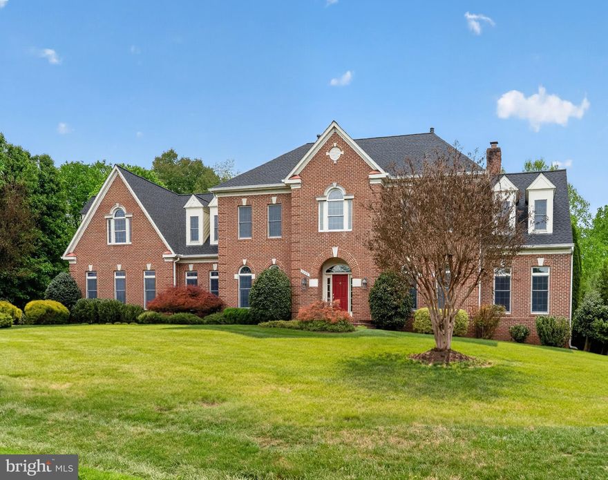 Nestled within the historic district of Colvin Run Mill, this exceptional colonial estate offers timeless elegance, expansive living space on a premium 1.05-acre lot. Showcasing brick on three sides and nearly 7,000 square feet of refined living space, the home features 5 bedrooms, 5 full baths, 2 powder rooms, and a spacious 3-car garage. Thoughtfully designed with soaring 10-foot ceilings on the main level and 9-foot ceilings upstairs and downstairs, the residence is filled with natural light and an open, airy ambiance throughout. The main level is perfectly suited for both grand entertaining and comfortable everyday living. A sun-drenched side sunroom flows seamlessly into the expansive family room, highlighted by rich hardwood flooring and a striking fireplace. The gourmet chef’s kitchen features a large center island, generous breakfast area, and a catering kitchen complete with an additional sink and full-size refrigerator. A private office and two powder rooms complete the main level.
Upstairs, the luxurious owner’s suite serves as a private retreat, offering a cozy sitting area with fireplace, dual walk-in closets, and a large bath with dual vanities. Four additional upper-level bedrooms include two with ensuite baths and two connected by a Jack-and-Jill bathroom. The lower level provides exceptional flexibility with expansive guest accommodations and abundant space for a future theater, recreation room or fitness area. Outdoor living is equally impressive, featuring a beautifully landscaped mature backyard and a private sport court ideal for pickleball, tennis, or basketball.
Ideally located in one of Great Falls’ most sought-after neighborhoods, this remarkable residence offers privacy and convenience just minutes from Tysons Corner, with access to top-rated Great Falls schools. PHOTOS & FLOOR PLANS MAY 14th