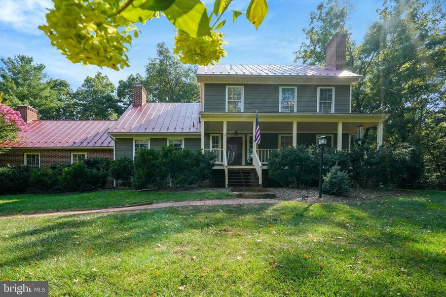 IMPROVED PRICE: Also, assumable VA loan at 2.375% in place if interested. In 1794 the Lee family built the historic Sully plantation in Chantilly Virginia which is now owned by the Fairfax county Park service. In 1979 a family decided to replicate that house at 13944 Aden Rd. HOME CANNOT BE SEEN FROM ADEN ROAD, SITS DOWN A LONG PRIVATE DRIVE HIDDEN AWAY FROM THE VIEW OF ANYONE. This exquisite custom home is an opportunity for someone who loves old world charm like that of historic Williamsburg only with modern conveniences. The property is a gardeners delight and offers so much privacy and gives the feeling you’re far removed from the busy urban world and yet everything you need is minutes away. Five acres of grand old trees and gardens that provide color and interest all year long. From the fenced garden area awaiting your plantings to stone walkways, a 10’ bridge that was built for a wedding, a fire pit and hot tub, garden/tool shed and hidden one acre fencing for your furry friends, the outdoor life is spectacular. A convenient circular driveway. There is more than a cord of firewood ready to burn outside the shed. The two + car detached garage has 50 amp electrical service and pull downstairs to additional storage. Gutter helmet system was installed in 2017 and has a lifetime transferable warranty. The water softener treatment system was purchased outright in 2018. The current owners had the entire home fitted with James Hardie plank siding and new wrap on windows and doors. The metal roof was just resealed and painted in June 2024. All of the chimneys were all power washed, sealed, got new crowns, repointed where needed, and a new stainless steel liner was installed to the woodstove in the kitchen. Many of the windows were also replaced this spring. Antique hardwood flooring runs throughout this house and the gorgeous staircases. Solid wood doors and entryways have solid eight foot doors with antique like hardware. The kitchen has a wood and beam ceiling and a working wood stove with thermostat. Lovely cabinets and quartz counter tops.  Bosch dishwasher and low profile brand new microwave. There is a moveable island that stays with the house. Behind the kitchen is a large mudroom that has a washer and dryer hookup (laundry is currently on the bedroom level),  a small tiled shower that could be perfect for washing the pups, storage, a closet and a  vessel sink and a ceramic wood look tiled floor. Both of the upstairs bathrooms have been completely renovated. The primary bath has a gorgeous tiled walk in shower. This home features 10 foot ceilings on the main and first upper level and spacious rooms. There is a huge finished attic with built-in bookcases, could be a home office or perfect for homeschooling. The main level features a bonus room that could also serve as a home office or possibly even an additional bedroom. The upper level features the primary bedroom and two additional bedrooms. The basement is partially finished with a full bathroom and great space for either a rec room or as it is currently being used for a workout room. So many awesome features, porches, eight fireplaces, wood lined ceilings, antique wide plank pine floors, spacious rooms, so much to see.  Want chickens? or goats or even cows?  How about those adorable miniature donkeys? Bring them here!