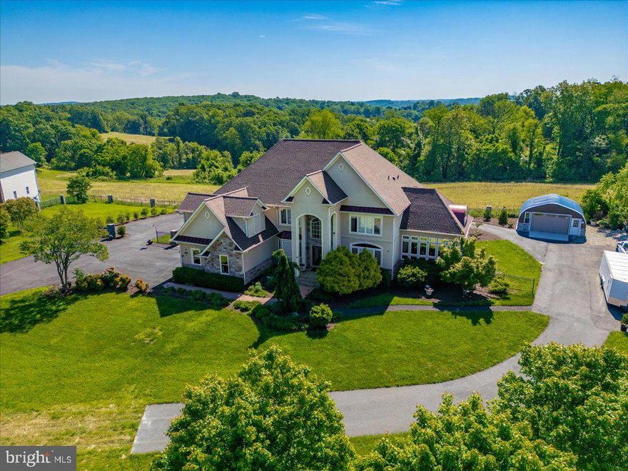 Welcome to one of Southern Frederick County’s most exceptional luxury estates, located in the highly sought-after Urbana High School district. This breathtaking property sits on over 1.4 acres of beautifully landscaped and fully fenced grounds, offering the perfect blend of rural serenity, timeless elegance, and refined functionality. As you arrive, a newly paved and sealed circular driveway framed by stunning stone columns creates a grand entrance and offers ample parking for guests. A detached one-car garage adds even more convenience and versatility. This stately home immediately captivates with its architectural presence and thoughtful design. Step through rich mahogany French doors into a gracious foyer with polished hardwood floors and fresh paint throughout. Natural light pours into every room, showcasing the home’s elegant craftsmanship, soaring ceilings, and high-end finishes. The flowing floor plan is both open and inviting, while still offering distinct spaces for entertaining, relaxing, and everyday living. At the heart of the home, the fully remodeled kitchen is a chef’s dream. It features sleek countertops, top-of-the-line stainless steel appliances, custom cabinetry, and an expansive island perfect for casual meals or conversation. The kitchen opens directly into the dramatic two-story great room, where towering windows frame idyllic views of the backyard and surrounding farmland. This home offers six generously sized bedrooms and eight bathrooms, including a luxurious primary suite that functions as a private sanctuary. Enjoy a separate sitting area, a walk-out deck overlooking wide-open fields, and a spa-like bathroom complete with a soaking tub, walk-in shower, and dual vanities. Every detail in this home is built for comfort and flexibility. The rough-in for an elevator on each floor—currently used as oversized closets—adds an incredible opportunity for future accessibility or multigenerational living. It’s a rare and thoughtful feature that truly future-proofs the home. The fully finished lower level offers over 2,500 square feet of additional living space and is ideal for extended family, guests, or even income-producing potential. It includes two bedrooms, a second fully remodeled kitchen, a large living space, a private theater room, and multiple separate entryways for added privacy and ease of access. Enjoy every season in the four-season conditioned sunroom, which brings the outdoors in with floor-to-ceiling windows, making it the perfect spot to sip your morning coffee or unwind with a glass of wine. Step outside and follow charming stone pathways that wind through lush gardens and lead to a fenced backyard oasis—ideal for entertaining, outdoor dining, or simply relaxing in complete privacy. This estate is also loaded with high-value upgrades: a brand-new roof, new well pump, a blue-light UV water filtration system, and a two-year-old hot water heater, all offering long-term peace of mind. These improvements blend seamlessly with the timeless architectural features and provide both modern convenience and enduring value. Located just minutes from Urbana’s vibrant town center, award-winning schools, shops, and commuter routes, this property offers a rare opportunity to own a luxurious, move-in-ready home in one of Frederick County’s most desirable areas. Whether you’re searching for a multigenerational estate, an entertainer’s paradise, or simply a peaceful retreat with room to grow, this is the one you’ve been waiting for.