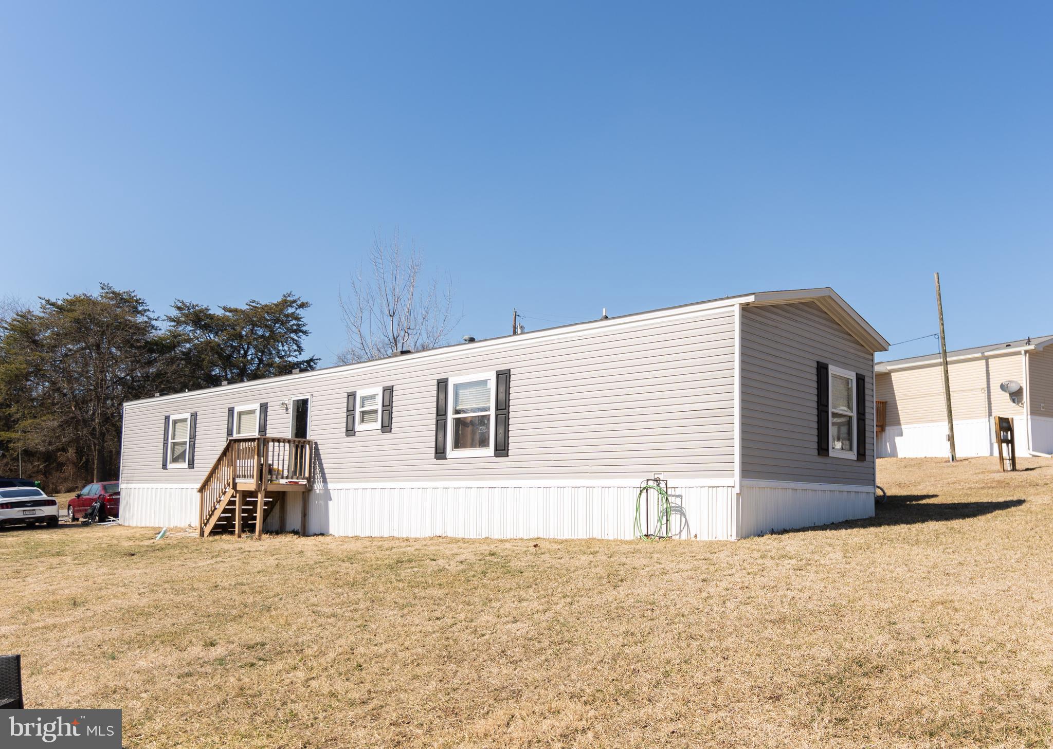 Check out this cozy mobile home featuring 3 bedrooms, 2 full bathrooms, and a welcoming living area. The primary suite includes its own walk in closet! The dining area has sheet vinyl flooring, and the kitchen is equipped with a stainless steel stove. The fridge, washer and dryer convey, and there's a small deck at the back, perfect for enjoying your morning coffee. Conveniently located just five minutes from shopping and dining, with Starbucks, Wawa, Five Guys, and Jersey Mike’s nearby. Positioned between Martinsburg and Winchester, offering an easy commute, and less than five minutes from the upcoming Butler’s Crossing retail center. A great starter home in a quiet, friendly community! The buyer must have their application approved by the community. There is a $400 ground rent fee.