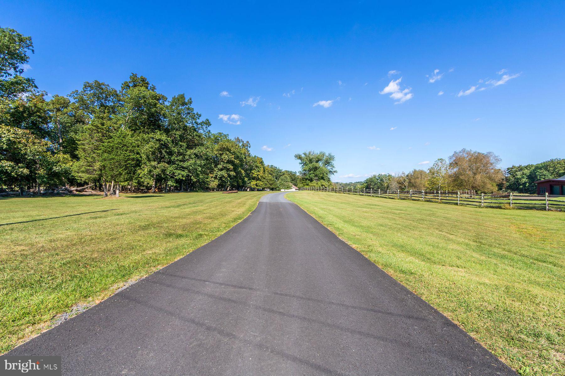 Drive down the long private driveway and arrive at this serene property surrounded by woods, wildlife, and the peaceful beauty of nature. Step through the front door into a spacious foyer with a pantry, coat closet, powder room, and laundry area for everyday convenience.
The custom kitchen is designed for both function and charm, featuring a butcher block center island, ample cabinetry, and a breakfast area that opens directly to the patio—perfect for enjoying morning coffee with a view of the property’s natural landscape. A large living room and a separate dining room with a bay window offer ideal spaces for entertaining and family gatherings. Completing the main level is a spacious three-car attached garage that provides both convenience and abundant storage.
The first-floor primary suite offers comfort and privacy, complete with a walk-in closet and full bath. Upstairs, you’ll find two additional bedrooms and a full bath. One bedroom includes an attached sitting room that can easily serve as a private office or reading nook.
The finished basement is a true bonus, featuring its own full kitchen, dining area, living room, bedroom, walk-in closet, full bath, and laundry—perfect for an au pair, in-law suite, or multigenerational living.
Outside, the property shines with a 36’ x 48’ pole barn equipped with two overhead doors, a workshop, loft storage, and a bathroom. The grounds also include a peaceful pond and wooded acreage that provide unmatched privacy and opportunities to enjoy evenings outdoors.
This home offers a rare combination of space, flexibility, and natural beauty, all while being conveniently located in Bucks County and close to New Hope, Doylestown, Frenchtown, NJ and Stockton NJ. Whether you’re looking for a private retreat, room for extended family, or a property with a workshop and storage, this residence delivers.