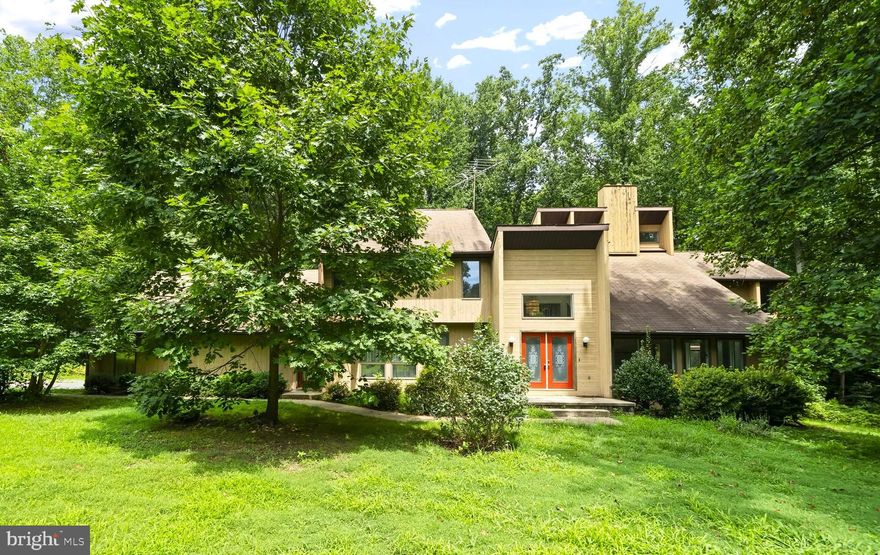 Spacious custom mid-century modern home on over 2 acres!  Beautifully situated on a corner lot in quiet neighborhood enjoy this carefully custom designed home. Double door entry leads you to your 2-story foyer. The great room has a gorgeous vaulted ceiling, windows all around, and two story stone fireplace. Formal living room and dining room. Main level laundry room. Your kitchen has loads of cabinet and counter space! Open island with cook top. The eat in kitchen leads to a rear yard deck great for barbequing and to the most relaxing 3 season room.  The primary bedroom is massive, complete with bedroom, sitting room with fireplace, and private balcony. The primary bathroom has a walk-in shower and soaking tub. There are 2 additional bedrooms and hall full bathroom on the level. Stairs on the side of the 3rd bedroom leads to the fourth level bedroom.  Flat backyard is perfect for relaxing in nature. A must see!