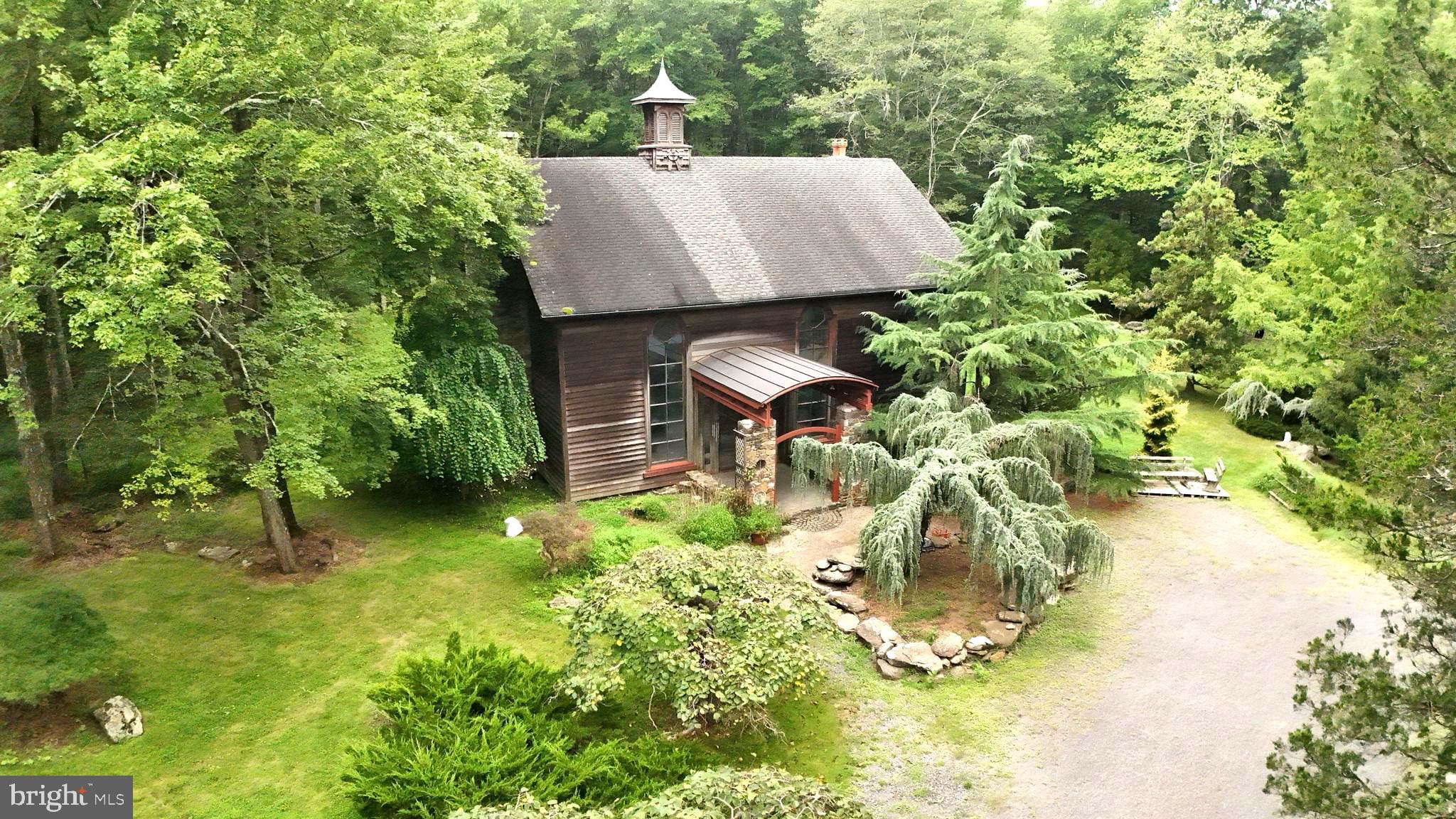 Welcome to this one-of-a-kind artisan home, nestled on over 20 acres of private, wooded land in Upper Bucks County, PA. This property is a true natural oasis, with an attention to detail inside and out, including many exotic plantings, a tranquil pond and a meandering stream that runs along its edge.
As you approach the home, handcrafted stone pillars welcome you into the interior's natural beauty and artistic touches that are immediately captivating. The spacious, open-floor plan is a masterpiece of custom craftsmanship and detail showcasing an array of mixed woods, with a first floor spanning an impressive 44' x 33' with 17.5’ ceilings. The floors are a work of art, designed with beautiful Bluestone and mosaic tiles that lead you to a magnificent natural stone fireplace.
The kitchen is a chef's delight, accessed through wood spindle double doors. It features custom cabinetry skillfully hand crafted with book matched cabinet doors, a Bosch 6-burner gas stove, a prep sink, ample granite counter space and open floor space for a future island.
A cantilever wood staircase ascends to the second-floor loft, which offers incredible flexibility. Currently configured with a bedroom and art studio/office, it also includes a full bath (a work-in-progress) wood flooring and space to add additional bedrooms and a laundry area. The home also includes modern amenities like radiant heat, an instant hot water system, a 240-amp generator plug, and both propane gas and a wood stove.
The estate is comprised of two distinct parcels, offering a perfect blend of seclusion and accessibility. One parcel features a sprawling 17.53 acres of lush woodland with a man-made pond and stream, while the other provides 3.91 acres with road frontage and a 500-yard stone driveway. The adjacent shop/garage/barn with open floor plan and loft is ready for you! Whether your hobbies are cars, horses or woodworking, this space allows you room to dream and expand.
Whether you're seeking a full-time residence, a weekend retreat, or a unique short-term rental property, this home offers endless possibilities. It's ready for a new owner to add their custom-build and complete its final vision.
Located just minutes from some of Bucks County's best-known natural attractions, this property is a gateway to adventure. You are a short drive from Nockamixon State Park, with over 5,000 acres for hiking, biking, fishing, and boating. Also nearby is Ringing Rocks Park, where a three-mile trail leads to a field of rocks that produce a distinct ringing sound when struck. With New York City only an hour and twenty minutes away, this is the perfect escape for those seeking a weekend retreat.
We invite you to the open houses: Thurs. Sept 4th from 4-6PM; Tues. Sept 9th from 4-6PM and Thurs. Sept 18th 12Noon – 2PM. This property is selling at public auction on Wed. Sept 24th at 4PM