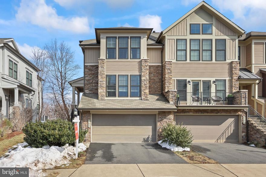 ** Open House Saturday February 21st and Sunday February 22nd 1-3 PM **Fall in love with this rare, contemporary carriage-style Miller & Smith–built “Carina” townhome, offering refined living on a grand scale in the heart of Brambleton. Thoughtfully upgraded with a new roof in 2019, this stunning residence features approximately 4,300 square feet of beautifully finished living space across three expansive levels, complete with a 2 car garage. Featuring 3 bedrooms, 3.5 baths, a covered screened-in porch, a patio, and a fully fenced backyard, this home blends modern elegance with everyday comfort and functionality. Enter through the north-facing front door and immediately sense the pride of original ownership reflected throughout the home’s immaculate condition. The main level showcases gleaming hardwood floors, 10-foot ceilings, and a welcoming foyer accented by custom shelving. Sunlight pours into the open-concept layout, creating a warm and airy atmosphere ideal for entertaining or relaxing at home. Hardwood staircases lead gracefully to both the upper bedroom level and the finished lower level, creating a cohesive and upscale flow throughout the home. At the heart of the main level is the gourmet chef’s kitchen, designed to impress with an oversized island and upgraded espresso soft-close cabinetry, including elegant glass-front cabinets. GE stainless steel appliances include a French-door refrigerator (2020), dishwasher (2020), a cooktop, a microwave, and an oven. A deep stainless steel sink and generous prep space make this kitchen as functional as it is stylish. The adjacent dining area, highlighted by a luxurious chandelier, flows effortlessly into the spacious family room, making gatherings easy and inviting. The family room is a true showstopper, anchored by a striking stone gas fireplace and a dramatic wall of glass with sliding doors. Sliding doors upgraded in 2021 open to the covered screened-in porch, seamlessly extending the living space outdoors. With recessed lighting, a ceiling fan, and a high-quality glass door, this porch delivers the ultimate indoor-outdoor lifestyle—ideal for morning coffee, relaxed evenings, or hosting guests year-round. Designer window treatments throughout the home add a polished, upscale finish. Just off the foyer, a versatile flex space provides endless possibilities as a home office, playroom, gym, or creative studio, complete with a generous closet for additional storage. Upstairs, the bedroom level offers a peaceful retreat. A serene primary suite features a tray ceiling, an elegant chandelier, and a spacious walk-in closet. The spa-inspired primary bath includes a sleek frameless glass shower with a built-in bench, double vanities with upgraded espresso cabinetry, a private toilet, and a linen closet. Two additional bedrooms share a well-appointed full bath with a tub and shower combination, while a charming loft with hardwood floors provides extra living or lounging space. Convenient upper-level laundry includes a washer and dryer (2022). The walk-out lower level boasts 9-foot ceilings and an expansive recreation room designed for entertaining, complete with a custom dry bar, shelving, wine rack, barstools, and a pool table. A full bath adds comfort and flexibility for guests. Enhancing everyday living, a UV air cleaner was added to the furnace in 2019, along with an upgraded furnace air intake filter in 2025, providing improved indoor air quality. All of this is set in a prime Brambleton location, where the association fee covers lawn maintenance, high-speed internet, cable, and more—giving you more time to enjoy life. Explore scenic trails, parks, and playgrounds, and Brambleton Town Center with its library, cinema, dining, and shopping. With top-rated schools and quick access to Loudoun County Parkway, Routes 50 and 28, the Dulles Toll Road, and the Silver Line Metro, this home truly offers exceptional luxury, convenience, and lifestyle.