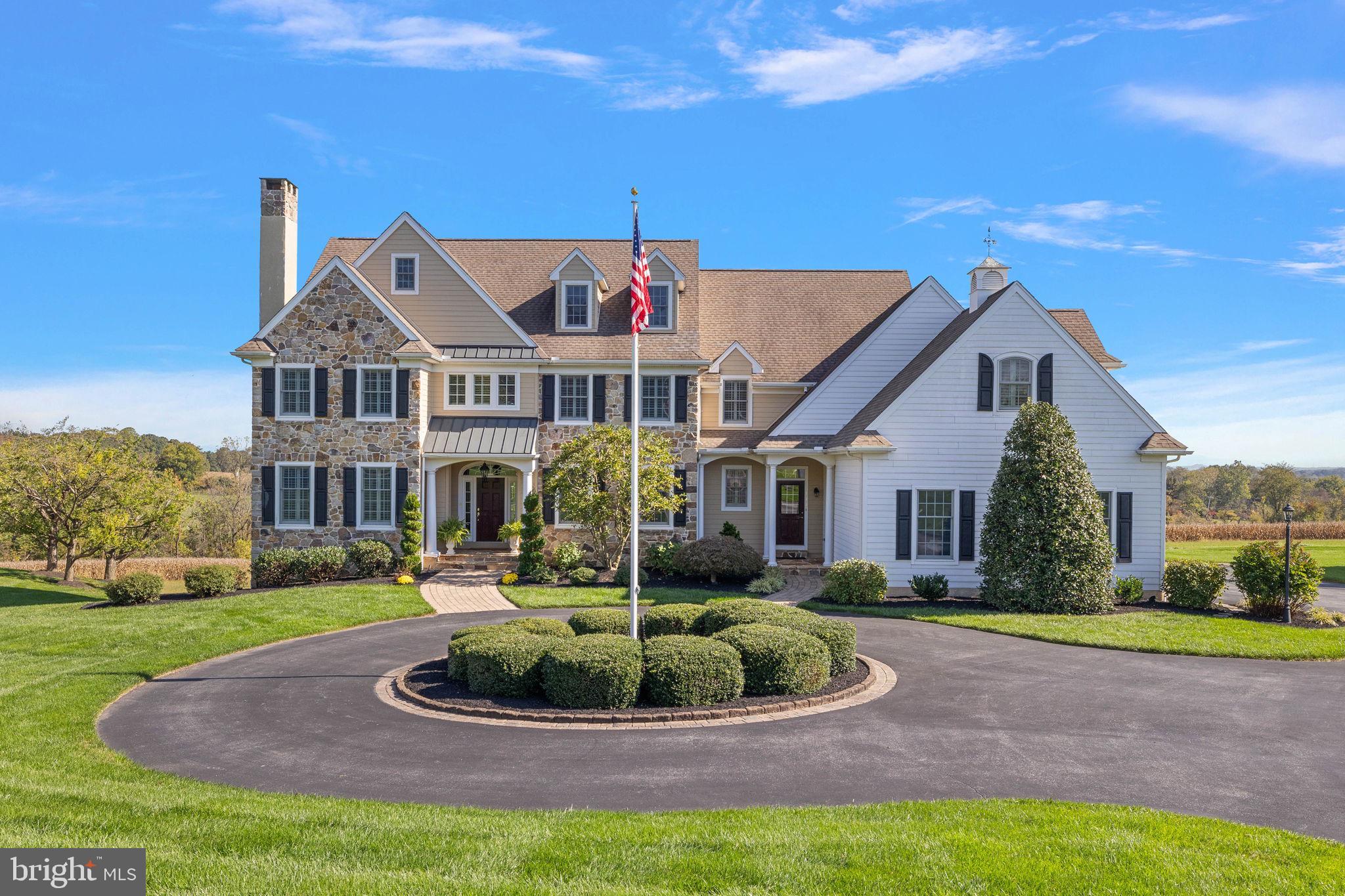 Newlin Greene – we could just stop the description there. What a fabulous neighborhood of beautiful homes all built within the last twenty years and in the Unionville-Chadds Ford School District. This home is THE one! Original owners occupying the house were the first to build and paid a premium for this one of a kind lot with expansive views and magnificent sunrises.
As you come around the circle cul-de-sac you’ll note the circular drive for easy access and extra parking when you have a house full of people. You’ll also notice the beautiful stone and hardie plank siding; all the stucco was removed in 2015!
As you enter the main door under the covered portico, you’ll be greeted by a spacious foyer, gleaming hardwood floors shining from the light offered through the French doors leading to the back patio. You’ll even have a glimpse of the view into the back yard that will surprise you as you enter further into the home. The formal living room is to the left and dining room to the right. You’ll immediately note the upgrades these original homeowners chose as you enter each room with arched molding, tray ceilings and extra deep crown molding. The neutral colors are warm and inviting and have all been continually freshened over the years. Behind the living room is a magnificent office with floor to ceiling built-in bookshelves, perfect for any work from home days. The enormous kitchen has tremendous work surfaces for the home chef and plentiful storage with beautiful cherry cabinets. A long island will hold many guests who want to watch you while you cook or help! For those guests who want to stay out of the kitchen, the space opens to a spacious family room with fireplace, vaulted ceiling and the best view in the neighborhood! These homeowners especially selected this lot and paid a premium because it is arguably the best location. The lot is just under an acre but with the view behind you will feel like you own 5 acres without the maintenance! The open concept area also has an eat in breakfast area which opens directly to a spacious paver patio from which you can entertain and enjoy the view. Every room on the main floor including patio and garage has hard wired speakers for your entertaining pleasure! Two powder rooms and mudroom round out the main level.
Upstairs you will find large 5 bedrooms. The primary suite has “his and hers” walk in custom closets and a very large bathroom with sunken tub, spacious tiled shower and separate sink vanities. Two more bedrooms are adjoined by a “jack n jill” bathroom and one of those bedrooms has a cool vaulted ceiling. Another guest suite has an en-suite bathroom that also functions as an extra bathroom for the bonus room/bedroom. Today this room is used as an additional den, but has plenty of closet space to function as a bedroom. A large laundry room is also on the 2nd level. The 3rd level is an enormous unfinished storage space, which is great to have in itself, but could easily be made into another finished space should the new homeowner desire. The lower level is unfinished but as you can see is large with high ceilings and walk out doors, so could easily be finished. It’s quite a comfortable space and the current homeowners use it daily as a great gym and play area. The garage appears to be 3-car, but wait! It’s really 3 and a half cars! The homeowners chose an upgrade of additional space and used it on either side to easily fit 3 cars plus trash cans and workshop space. Not all homes have such a thoughtful plan.
The upgraded touches in this home go on and on, from the shutters on the windows to the extra space over the garage, the additional molding in the house etc. And includes the newer windows in much of the home.
You must see this special home for yourself. Make your showing tour today!