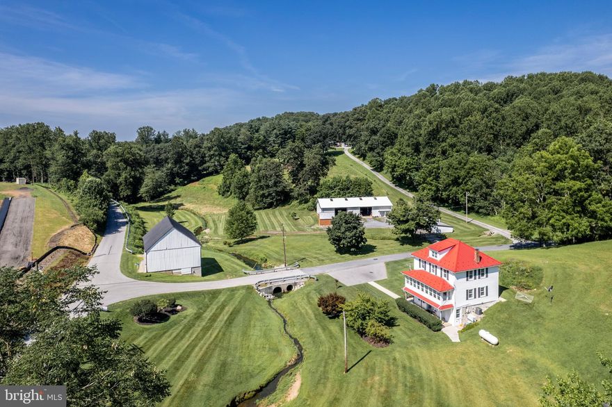 Almost seven acres with two streams.  Family farmhouse converted from original mill.   Super-size Morton pole building with highbay door large enough for your RV, boats or oversized stuff.   Garage equipped with automotive lift and large air compressor to power your air tools.  Garage has water and electric.   Large barn good for your animals and even more storage.  Open bay flex use building and enclosed hen house.   Country kitchen in house recently renovated.  Solid hardwood handmade oak cabinetry painted a soft sage with quartz countertops and stainless appliances give you modern convenience in a rural setting.  Lots of parking.  This is Carroll County living at its best.