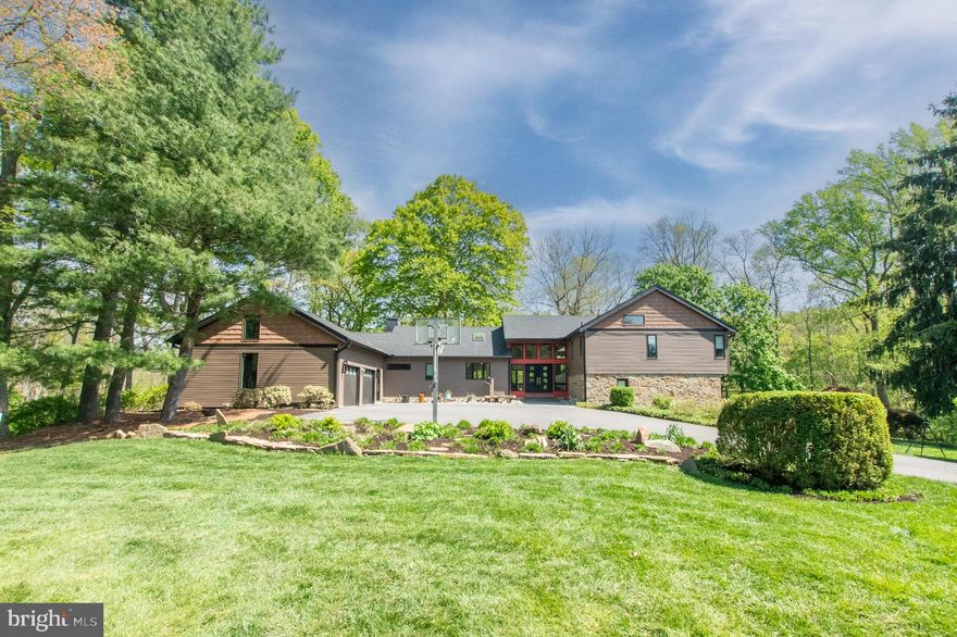 It’s so rare that a house that checks all the boxes comes on the market.  The location of Birmingham township, Unionville Chadds Ford School District, a private 4 acre lot, cul de sac street, over 4500 square feet with no HOA rules. All located in the discreet neighborhood known as Roundelay where sales are sparse. This is historic Chadds Ford area, minutes from Longwood Gardens, 2 miles from Brandywine Museum, and a few miles from the DE border.
Located on a small, quiet cul de sac street with other widely spaced homes that are unique and not alike, this four acre property, that backs to the Brandywine Conservancy, has you at one with nature. Healthy trees, blooms, wildlife, chirping birds, a stream and the most gorgeous mature miniature Japanese maples encompassing this blissful retreat.
A stunning contemporary with its impressive combination of varying textured siding, monochromatic shades of neutral colors, stone, differing heights of roof, angles, and that mesh together that create a mesmerizing work of art that’s 910 Roundelay Drive.  Once you pull into this aesthetically gorgeous tree lined driveway, you’ll see the superb, perfect burst of color framing the front door that just begs to welcome you inside.
Enter into home and you will be captivated by the cathedral ceilings, skylights, Charcoal porcelain tiled flooring, custom enhancements of quality that is complementary to the style house. Every line, pop of color, light fixture, door, window, etc. is a well thought out design that no expense was spared and it shows. This is the look of today.  Multi levels that a adds a nice  touch of dimension, just a few steps to each level. Functionality with quality in the fabulous new kitchen with soft touch kitchen cabinets, sub zero refrigerator, Wolf appliances, quartz counters, steam oven, coffee niche and pantry.
So much space that offers rooms for everyone with multiple hobbies and needs. Immense play/everything room, sunroom, living room with stone fireplace, tiled bathrooms, 4 large bedrooms & mudroom with custom coat rack and cubbies are some of the notable features. With an abundance of windows & glass doors, the natural light beams throughout this sprawling home and showcases the beautiful views. Very unique and must see.
Make an appointment today and see this visually captivating home that offers so much. Showings start May1.