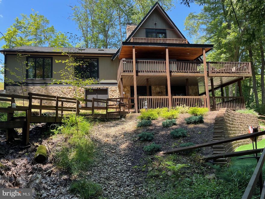 Enjoy lakefront living at its finest in this beautifully remodeled home with a private dock. Thoughtfully updated with modern finishes including a kitchen remodel, new windows and doors, new upper balcony, new flooring throughout, and recently added mini splits on the lower level. This property offers stunning water views, an open-concept layout, five bedrooms (three of which are en suites), and two-family rooms. The exterior space offers seamless indoor-outdoor living that includes a built-in bar area with a Blackstone grill and a firepit area off the lower level, perfect for relaxing or entertaining. Whether you're seeking a full-time residence or weekend getaway, this home delivers the ultimate waterfront lifestyle.