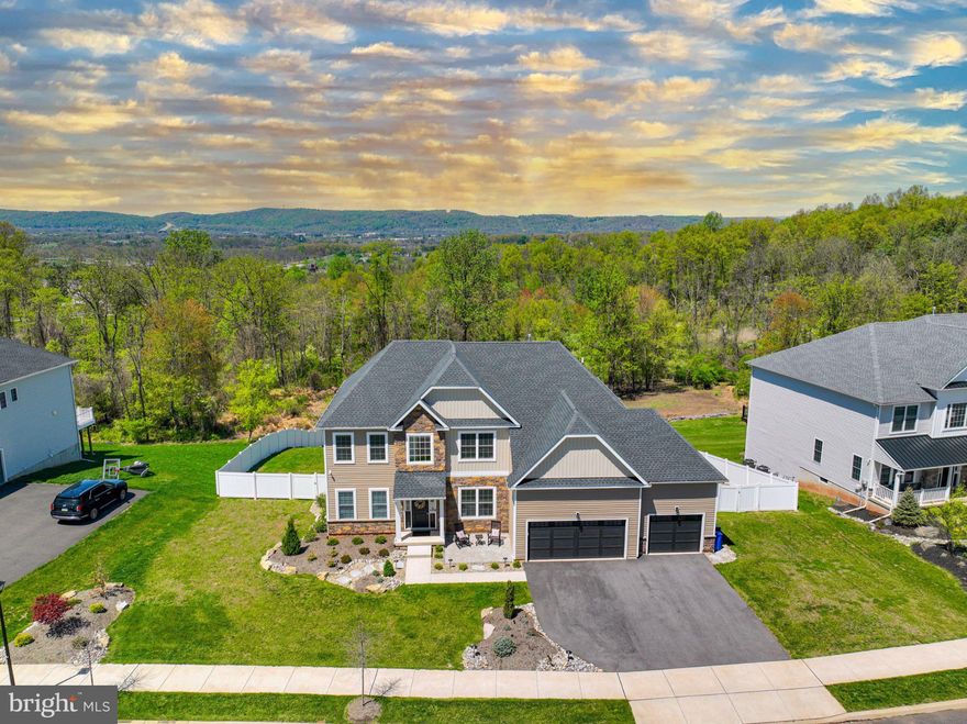 Positioned on one of the most desirable homesites in the Estates at Saucon Valley community, this home offers rare privacy and uninterrupted valley views. Spanning over half an acre, the property delivers a truly exceptional setting. The first floor is anchored by a two-story family room with expansive windows framing the views, a gas fireplace, and an open staircase that defines the space, all connecting seamlessly to the kitchen. The kitchen is centered around an oversized island with abundant cabinetry and a layout designed for daily use and entertaining. Upstairs offers four generously sized bedrooms with custom closet shelving and the convenience of second floor laundry. The owner’s suite provides a comfortable retreat with a well-appointed bath including a soaking tub, tiled walk-in shower with bench, double vanity, and a spacious walk-in closet. The finished walkout lower level adds flexible living space, ideal for a media room, gym, or guest area, complete with a full bathroom. Built for modern living, the home features fiber powered internet, whole home mesh WiFi, and hardwired connectivity throughout. A comprehensive security system with lighting automation adds convenience and peace of mind. Two dedicated home theater spaces and a deck prewired for TV, audio, and internet create a seamless indoor-outdoor experience. The outdoor setting is expansive and private, creating a scenic backdrop. Located in the Southern Lehigh School District, just minutes from Saucon Valley Country Club, The Promenade Shops, and major commuting routes, this home delivers a rare combination of privacy, views, and turnkey condition.