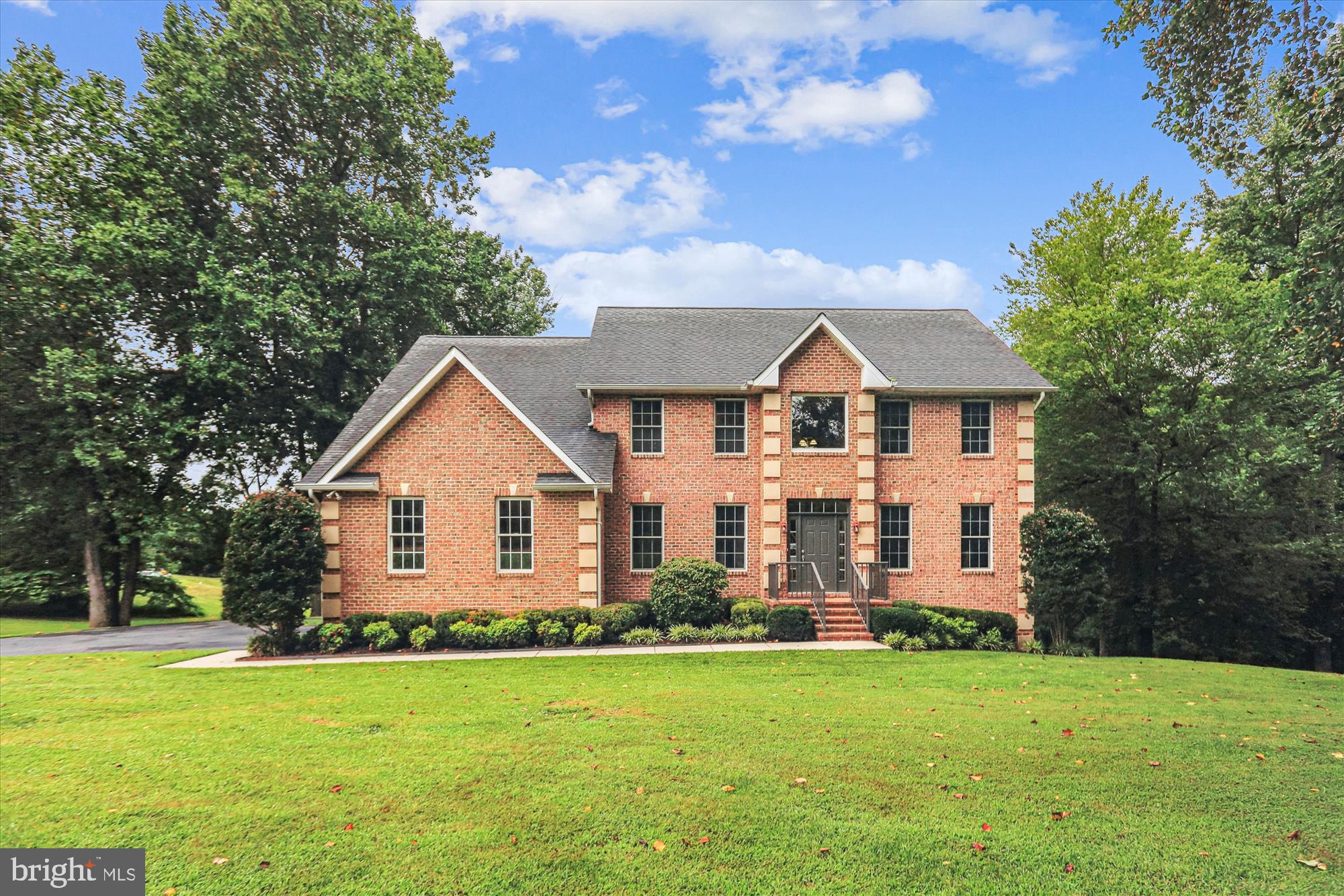 Love where you live! Beautiful country setting in close proximity to local amenities and commuter routes to Annapolis, DC and other major areas. This brick home is located on 4.79 acres and offers approximately 5,500 sqft of living space on three finished levels with personalized space for everyone including a home office and gym. The main level offers refinished hardwood floors, an open floorplan with a large kitchen boasting granite counters, walk in pantry and stainless-steel appliances. The centralized living room with a gas fireplace and access to the rear deck is a focal point and emphasizes the seamless transition between the living spaces on the main level. The upper level offers four bedrooms with a large primary suite. This suite boasts a gas fireplace, large bathroom with soaking tub, laundry room and walk in closet. Also on this level is a second bedroom suite with full bathroom. The lower level offers an abundance of natural sunlight, a home gym, 5th bedroom, full bathroom, 2nd laundry area and a large- finished area to create your own personalized space. Located on one side of the yard, with a separate driveway entrance, is a fully finished 50x70 steel building built in 2014 with large bay doors and concrete floors. All of this and no HOA.