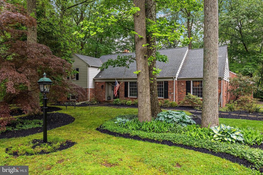 Nestled in the picturesque neighborhood of Surrey Park, the stunning residence at 3325 Coachman Road embodies the elegance of New England style with the convenience of contemporary living. This magnificent split-level home, covering a generous 3,475 square feet, invites you with its antique brick façade and charming open floor plan.

From the moment you step into the foyer, you are greeted by the warmth of custom built-ins in the living room and hardwood floors that flow seamlessly throughout the home. The expansive family room, featuring a raised hearth brick fireplace and built-in shelving, creates an inviting atmosphere, perfect for both relaxation and entertaining.

The heart of the home is its newer, state-of-the-art kitchen, equipped with Bosch stainless steel appliances, including a dishwasher, 5-burner gas cooktop, and a built-in convection microwave. The kitchen effortlessly merges with the family room, offering an open concept that showcases views of the lush, wooded surroundings through a wall of windows and French doors.

A private sanctuary awaits on its own floor, where the primary suite boasts an updated full bathroom, luxurious dressing room and not one, but two walk-in closets. The additional bedrooms, located on their own level, provide ample privacy and space for family or guests.

Step outside to discover the serene beauty of the screen porch and deck, perfect for afternoon teas or evening gatherings, all while overlooking a tranquil rear yard bordered by a gentle stream. Adjacent parkland on two sides enhances the sense of seclusion and natural beauty.

Further enhancements include a versatile recreation room, a 3rd full bath on the lower level that is ready for you to give the finishing touches to,  and an oversized garage with a service door. This home is a masterpiece of construction, offering a harmonious flow and an open floor plan that truly makes it a must-see property.