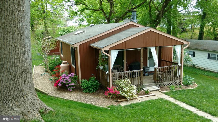 This well loved, two bedroom, cottage home is situated on 8 lots totaling  .368 acres.  The living room has a gas fireplace that can be converted back to a wood burning fireplace if desired.  The eat-in kitchen has a 5 burner gas stove and a double sink.  The pantry has deep drawers that pull all the way out.  The movable kitchen island has plenty of storage space on all sides.  The bathroom has lots of natural light coming from the skylight.  Outside you will find a perfect front porch for relaxing and enjoying the beautiful landscaping.  There is a bike ramp coming off the parking pad so that you can store your bikes in the rear of the house.  The wonderful landscaping continues into the fenced backyard.  A double shed, to store your yard equipment and/or bikes are an extra bonus.