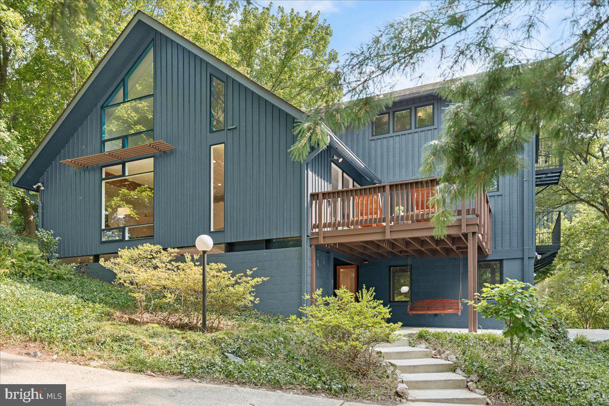 Mid-Century modern meets California contemporary featuring a fantastic primary suite renovation! This is a truly special home that has been significantly expanded, extensively remodeled, and recently improved. Nestled into a gentle hillside, on a private cul-de-sac just steps from trails and nearby parkland, this home looks out over the tree-tops. The interior enjoys open spaces with floor-to-ceiling windows offering idyllic wooded views all around. A sun-drenched and expansive open concept living room and dining room with wood-burning fireplace is perfect for entertaining. The main level also features a home office, an entry hallway with ample coat and storage closets, newly installed recessed lights, and a bedroom suite with adjoining full bathroom that includes a brand-new vanity. The kitchen offers generous counter space, abundant custom shaker-style cabinetry, stainless steel appliances, a brand-new stove, recent microwave and refrigerator, ceramic tiled floor, and a convenient pantry. Flooded with natural light from the western facing sky beyond, the spacious family room and breakfast areas are just off the kitchen. French doors in the family room lead to a wrought iron balcony overlooking the front yard and a delightful deck off the breakfast area offers an opportunity to enjoy sunsets and alfresco dining. A floating staircase leads you to the upper level where you'll find the sumptuous primary bedroom suite. With its vaulted ceilings, richly stained wood floors, and french doors to a balcony you'll feel like you're on vacation every day, especially when you step into the luxurious primary bath retreat! A double basin vanity sink, high-end ceramic tile, designer fixtures, custom built-ins, and accent lighting offer a spa-like experience. The primary suite also includes two walk-in closets with built-in custom storage. The two additional bedrooms on the upper floor feature vaulted ceilings, walls of glass, custom closets, built-ins, and share a renovated ceramic-tiled hall bath with tub. The lower level of the home provides an abundance of natural light since nearly half of it is above grade. Bring your imagination - there are rooms aplenty to use for recreation, play spaces, guest rooms, home offices, or for a home gym. There is a separate outside exit to a porch swing on the patio, and you'll even find a sauna and hot tub, plus abundant storage areas. The entire home has been freshly painted and new carpet installed in the lower level rooms. The utility room features two work benches, storage space and updated front-loading washer and dryer. The HVAC system is dual-zoned and is controlled by Nest thermostats. A Generac home generator for backup power and an electric car charger installed in the carport are just a few of the amenities you'll find. Ideally located, this home has easy access to nearby parks, trails, and the C&O canal. There is nearby shopping and dining as well and the home is also within walking distance to the newly renovated, popular Mohican Swim Club with a transferrable membership! The home provides easy access to downtown DC, Northern VA, and points north (I-270) and east via the Beltway. Situated in one of the finest school districts the country, Walt Whitman H.S., Pyle M.S. and Woodacres E.S. , this home's school district feeds into high performing schools year after year. Welcome home!