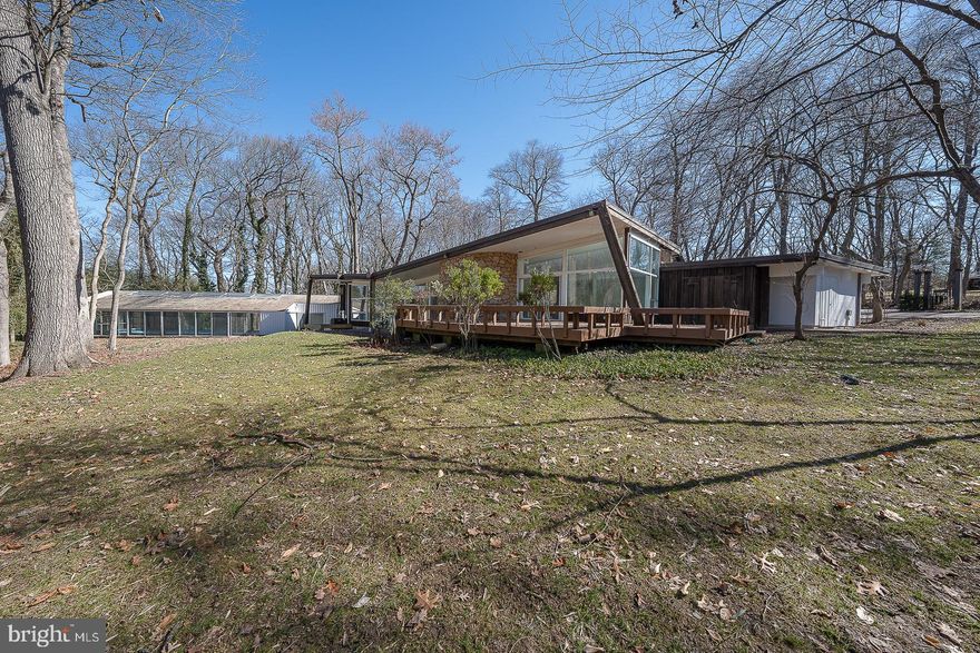 Located on one of the most desirable streets in Penn Valley, this mid-century modern home sits. Immersed in the beauty and privacy of lush, mature trees, 39 Fairview Road offers architectural and design elements throughout the fabulous living space. The stone exterior, front courtyard, and double carport are highlighted by subtle earth tones, setting the scene for the home's interior. The entryway leads to an impressive living room with new tile floors, high ceilings, recessed lighting, floor-to-ceiling windows, a unique curved fireplace, and a sliding glass door that opens to a spacious deck. The dining room, which can accommodate large and intimate dinners, includes a high ceiling and a sliding glass door to the stone patio. The dining room flows into the kitchen, creating an ideal space for entertaining.   The updated eat-in kitchen has it all -a large island, high-end appliances, ample cabinet space, a spacious breakfast area, a wall of windows allowing an abundance of natural light to flood the room,  and access to two separate stone patios. A long corridor, lined with closets, leads to the spacious primary bedroom suite, which includes 3 walk-in closets, an ensuite bathroom with double vanity, bathtub, and a glass-enclosed shower.  Sliding doors lead to a tranquil atrium and to the private den/office with a wall of built-ins.  There are 5 additional bedrooms with great closet space and natural light, one with an ensuite bathroom and one full hall bathroom, completing this level.  The lower level is ideal for an au pair or in-law suite with a private bedroom and a full bathroom.  Completing this wonderful home is a large indoor pool, ideal for lap swimming or relaxing with family and friends.  The rear deck and patio are ideal for both relaxation and entertaining. This home is truly a rare find and has endless possibilities. Located in the award-winning Lower Merion School District and conveniently located near dining, shopping, entertainment, as well as major roadways and public transportation, allowing an easy commute to Center City.