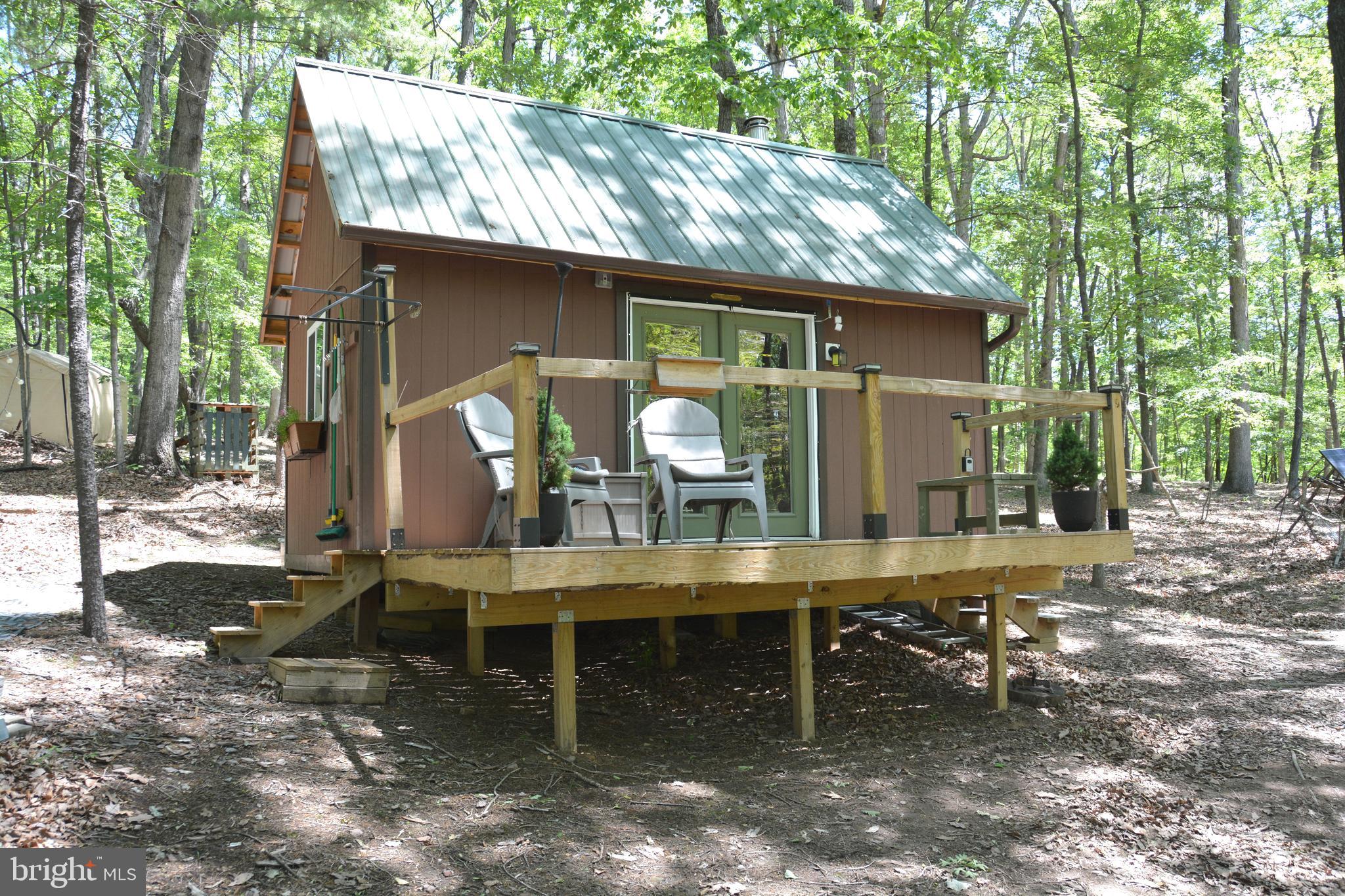Adventurous personality, love nature, hiking, hunting, relaxing, like your privacy. No covenants or restrictions on this almost 10 acre lot. A small creek separates each side of the land. The property is at the very end of Files Chapel Dr. All the land is to the left side. This front part of the land is where a perc site was approved years ago. Some trees were removed for a drainfield area. If you walk into the land, it falls off sharply to the creek below. There are steps carved in about halfway down. Cross the bridge over the creek, and then make your way up the next steep hill, again with steps carved in. Once you get to the top, the land levels off nicely. No electric, no plumbing, but a very neat 12 x 20 cabin/cottage with vertical wood exterior siding and metal roof. The interior has been finished off nicely with wood/laminate flooring, vaulted ceiling, horizontal pine walls, woodstove, small loft area. The inside of the cabin is very comfortable. There are solar panels set up outside that feed into a small generator, dispersing electric to lighting, (phone)chargers, Yeti. There are a couple of tent canopies for storage along with "outhouse facilities". Very private here. You can shoot, hunt, burn a campfire. You can feed the deer right off the deck! The ATV, utility trailer, tools, the interior furnishings, will convey. Ribbons around the perimeter are approximate. Bring your energy bars. It is quite a hike up and down the mountain!