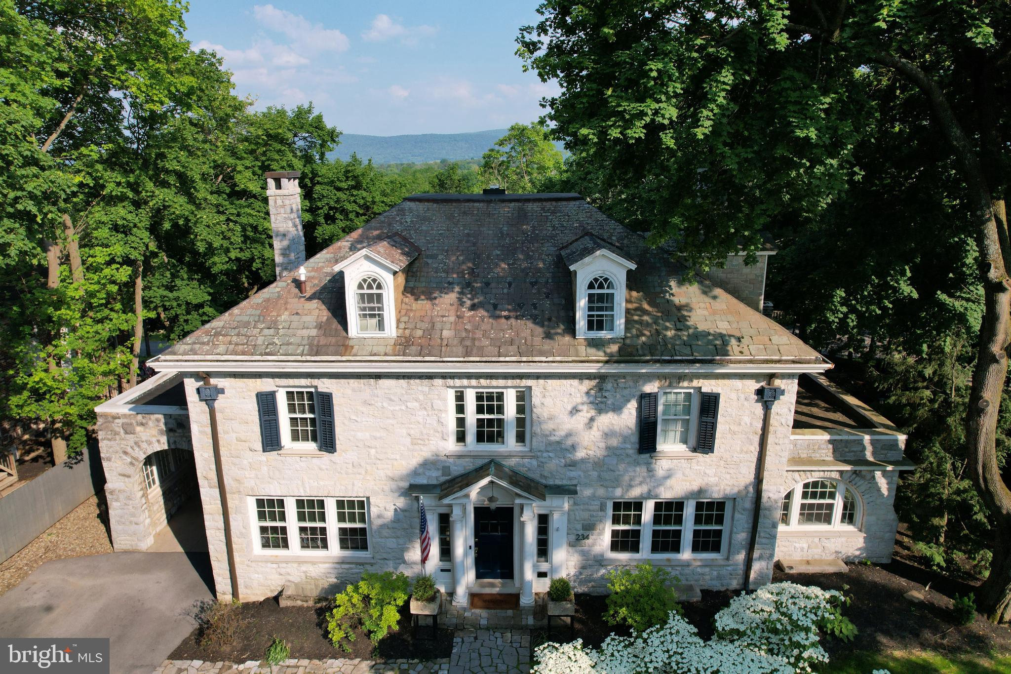 In the heart of downtown State College, this remarkable 1922 stone home—designed by noted architect A. Lawrence Kocher—offers 6,820 finished square feet of timeless elegance and modern functionality across four levels of the main house plus a fully renovated carriage house. Set on a spacious .40-acre lot, the main home features 5,406 sq ft above grade and 1,414 sq ft of beautifully finished lower-level space. Additional information available on current rental permits and income as well potential ability to increase in occupancy for full B&B operation.Â
A classic Georgian Four Square layout with a large entry foyer opening to all main rooms allowing for unparalleled entertaining. Thoughtful original details throughout the home include crown molding, real wood floors, French doors to most rooms on first floor, stairway railing and windows. Care has been taken by current owners to bring the home into a new modern era without eliminating the character and visual appeal of this period masterpiece.
Walk into the heated vestibule complete with coat closet with a window and custom door. Mail is delivered right into your mailbox that opens directly inside. Continue through the French door into the main foyer. You can see every room from this vantage point.
The fabulous kitchen was painstakingly designed to hide all your necessities yet leave them in easy reach. The quartzite countertop wraps around for ample workspace. Notice how the countertops were designed on a full flat level rather than lowering in front of the windows. A 5-burner gas cooktop with custom hood and backsplash. Built in dual ovens with convection and microwave. Built in Bosch coffee station.
Open living room, dining room and small office/nook complete the main floor. A beautiful living room gas fireplace is visible from the hallway. All the wood floors on this level have been recently refinished and the walls and trim painted.
Off to the far right there is an enclosed side porch with a fireplace that opens to the yard. Lined with windows it a bright sunny retreat. French doors to the living and dining area are original.
The staircase to the second floor features a large window that views mountains. A large landing foyer that opens to all rooms. 4 bedrooms, each with their own bath. The primary has a fireplace that is not in use. A walk-in closet can be entered from the bedroom and bathroom. Large bath has radiant heat floor, jetted tub, stall shower, double vanity, Toto toilet and heated towel rack. Connects to a bedroom that can be closed off or used as additional closet space.
Two additional bedrooms have captive full baths, one recently remodeled. The third floor has two cozy bedrooms with nooks and crannies and captive full bathrooms. A cedar closet is located here also.
The backyard is an oasis with several stone patios for small intimate gatherings or large-scale entertaining. A pond with running stream and fish sends soothing sound through the yard. This is a favorite feature of the current owners. There is an electric fence for your pets too.
The main house exterior is all stone with a slate roof. Parking is ample with capacity for 13 cars on the property. There is also street parking nearby.
This is the only property in the Borough of State College zoned as a Bed and Breakfast. Current rental permits for Carriage House and Lower-level rental.
This one-of-a-kind property offers unmatched walkability to Penn State University, downtown shopping, restaurants, and nightlife—all while providing an expansive, private retreat in the center of it all.
Bedroom & Full Bathroom listed on Main Floor in Room Count fields represents the Carriage House bedroom and bathroom. More details available to agents in documents tab.