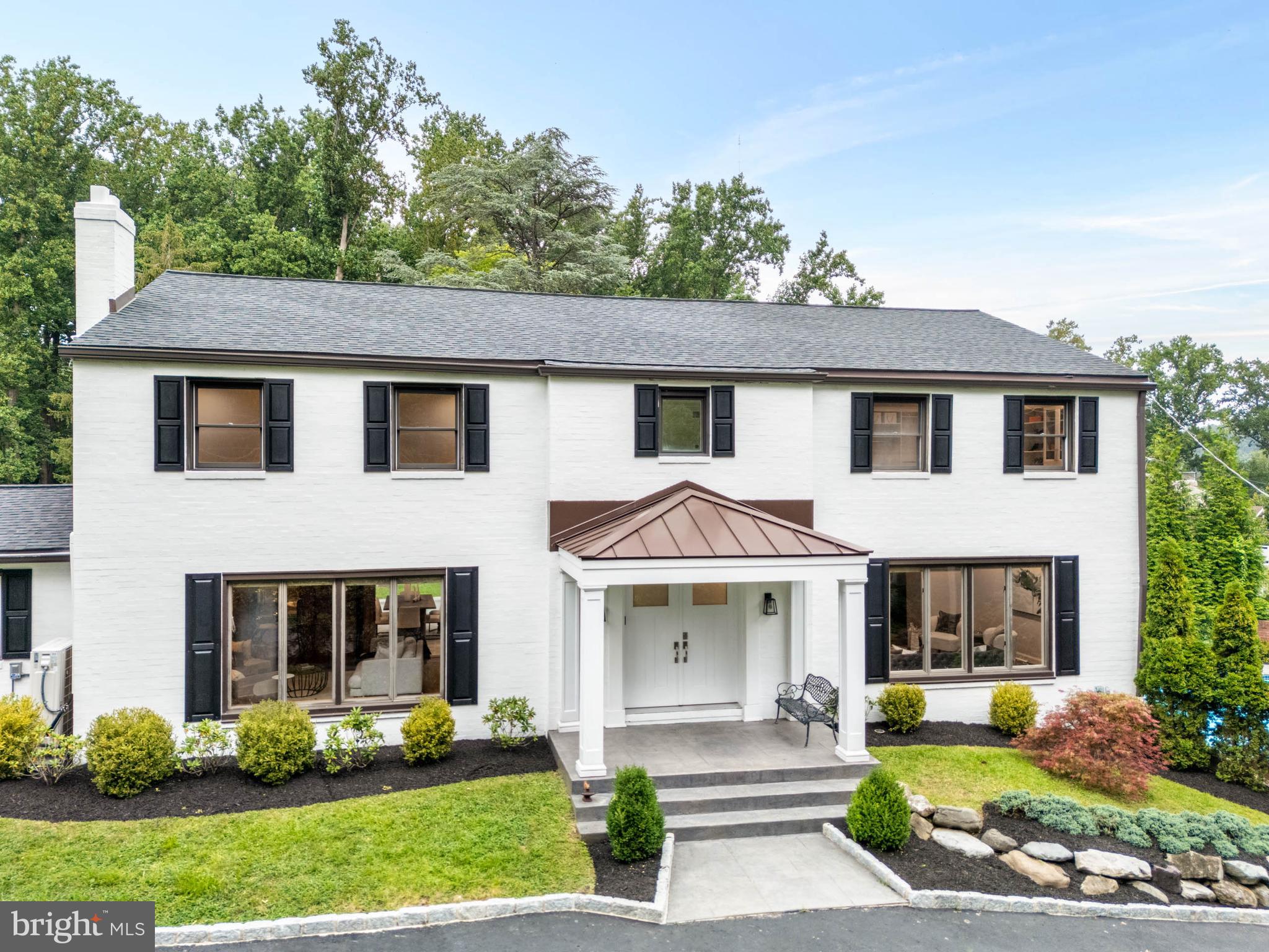 Welcome to 1600 Flat Rock Road, a beautifully finished white brick Colonial estate offering over 4100 sq/ft of elegant living space. Nestled on nearly 1 acre in Penn Valley, offering unique amenities including an updated in-ground pool and a tennis court. This 4-bedroom, 3.5-bath home is sure to impress even the most discerning buyer. Enter into the two-story foyer with a graceful curved staircase that sets the tone for the contemporary and classic styles found throughout. Step down into the spacious family room with an abundance of natural light and the adjoining dining room, creating an ideal space for hosting dinner parties and gathering with loved ones. On the opposite side of the foyer, a versatile living room/study/den features parquet floors, a gas fireplace, and built-in bar, adding a sophisticated mid-century modern flair to the space. The updated kitchen features a 4-person seated island, white quartz countertops, dual sinks, and custom Porcelanosa cabinets. A convenient laundry room, half bath, and access to the two-car garage complete the first level. Upstairs, the primary bedroom offers wall-to-wall closets and a luxurious en-suite bathroom featuring a tiled walk-in shower, soaking tub, dual vanity, and a separate water closet. The adjacent bedroom has been customized into a dream walk-in closet, providing ample space for your wardrobe and daily preparations, that would be easily repurposed for another bedroom. Across the open landing, two additional bedrooms with generous closet space share a full hall bath with a shower/tub combo and dual vanity. The fully finished, walk-out lower level provides valuable flexible living space, perfect for an au pair or in-law suite, or for entertaining. It includes a brand new full kitchen, living room, bedroom, and a full bathroom with changing area, the perfect area for pool parties and sleepovers. Walk right out of the basement to your own private oasis with a large deck and an in-ground pool with hot tub. Walk up the slate stairs to the rear deck and the fenced-in tennis court, easily convertible to a multi-sports court, basketball, pickle ball or a children's play area. Perfectly situated in the award-winning Lower Merion School District, this magnificent home offers easy access to center city, restaurants, parks, and all that Penn Valley has to offer. Don't miss this incredible opportunity, schedule your private tour today!