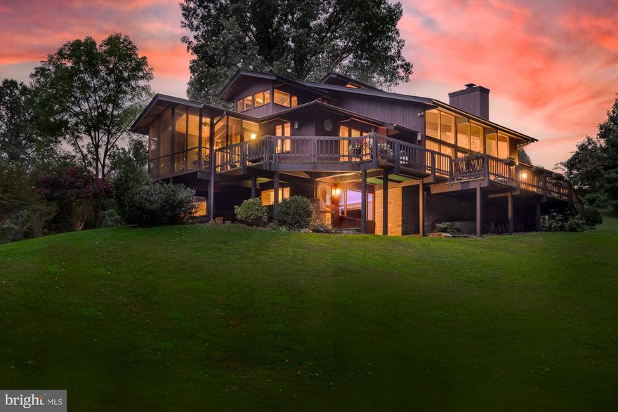 Welcome to this stunning contemporary and rare custom built Deck Home.  
Through the use of complementary cedar, mahogany and brick materials and colors, this Deck Home is perfectly harmonized with its natural surroundings, forming a unique and masterful sense of elegance and calm.  This is truly a one of a kind home that is not found in this area.  The main home spans 4,834 finished SF on 1.95 acres to include an 1,824 SF garage and workshop.  This home offers a serene retreat, backing up to Mason District Park. This park offers access to scenic trails, an amphitheater, sports fields, a playground and more right from your doorstep.
The residence features an open floor plan enhanced by soaring cedar ceilings with wood beams, bringing a sense of spaciousness and light. Floor-to-ceiling windows in the two-story living room offer panoramic views of the surrounding forest, while a stone natural wood fireplace with a slate hearth and mahogany mantel adds a touch of rustic charm. The living area is complemented by a wet bar with quartz countertops, a wine refrigerator, and custom-designed mahogany shelving, perfect for entertaining.
The expansive kitchen features a center island, soft-close drawers, quartz countertops, and top-of-the-line  appliances, including a cooktop, refrigerator, oven, and microwave. Large windows in the kitchen offer panoramic views of the surrounding landscape, seamlessly integrating the indoor space with the outdoors. Adjacent to the kitchen is a screened porch with a vaulted cedar ceiling and ceiling fan, providing a delightful space to further enjoy the picturesque setting.

The main level includes a luxurious BR suite featuring a built-in platform bed, cedar-lined walk-in closets, and cathedral ceilings. French doors open from the bedroom to a deck, offering beautiful views. The main bath has been meticulously renovated with a walk-in shower, a soaking tub, and heated floors. Additionally, a second bedroom with a separate bath is also located on this level, providing both comfort and privacy.

Upstairs, an expansive loft area opens to a 3rd BR with a private outdoor Trex deck, a bathroom with skylight, & exquisite office space.  The office is designed to inspire productivity and creativity, featuring breathtaking 180-degree views that immerse you in the beauty of the surrounding landscape. The room is bathed in natural light from surrounding windows, creating a bright and inviting atmosphere.  The office is furnished with a custom-built cherry desk, which exudes sophistication and craftsmanship. This elegant desk provides ample workspace and integrates seamlessly with the room’s design, making it a perfect setting for both work and reflection.

The finished lower level offers a spacious suite to include a 4th bedroom with a full bath, den, and large entertainment area.  Unique to the lower level is its spa like atmosphere which includes a large cedar lined dry/wet sauna to help maximize your health and well being.   The suite provides convenient access to the outdoors, enhancing your living experience with seamless indoor-outdoor flow. Additionally, the large storage room features a high ceiling and custom shelving for all your storage and organizational needs.

This home features a 3-car Attached Garage with Custom Cabinetry and a Fully Renovated Detached Garage/Workshop, which includes Heated Floors and Extra Storage or Vehicle Space.

Improvements:   Modern HVAC Systems |  Roof Replacement for  Main House &  Detached Garage |  All-New Skylights | Custom Gutters | Renovated Detached Garage/Workshop with Custom Cabinets | Custom Workbenches |  New Garage Door | Heated Floors | Newer  Washer and Dryer | Repaved Driveway | Custom Lighting throughout | Swarovski Crystal Chandelier in the Foyer.

This Deck Home, with its harmonious blend of natural materials and contemporary design, offers a unique and inviting living experience.  Don’t miss your chance to own one of the most unique homes in Northern VA