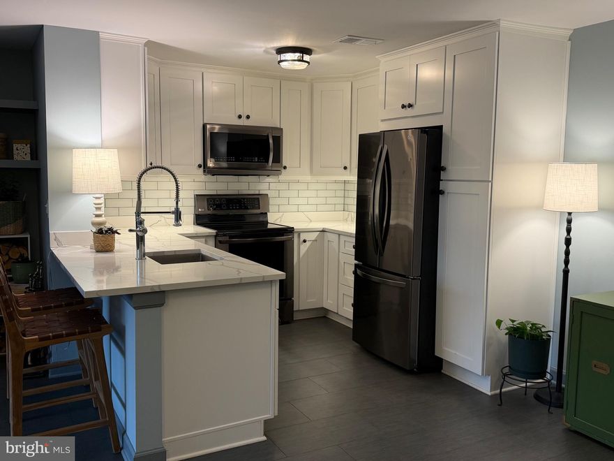 Welcome to this beautifully renovated and spacious one-bedroom condo in the heart of Reston!
From the moment you walk in, you’ll notice this home is truly exceptional.
The chef’s kitchen has been thoughtfully redesigned with matching LG Refrigerator & Range, & brand new GE Dishwasher. Ceiling-height quality cabinetry with crown trim and under-cabinet lighting, elegant quartz countertops, and stylish tile flooring. The breakfast bar was opened to counter height for a more inviting and functional layout, and a premium Hydroviv water filtration system serves both the sink and refrigerator water/ice.

The living room centers on an elegant antique fireplace mantel with custom shelving, offering both charm and function. Natural light pours in through a new triple-pane Vinyl Max sliding glass door leading to your private patio, perfect for morning coffee, al fresco dining, or a little container gardening.

Throughout the main living areas, you’ll find gorgeous low-maintenance tile flooring, while the spacious bedroom boasts high-end LifeProof LVP flooring, dual custom closets with built-ins and premium doors, a modern barn door entry, and additional wall shelving for maximum storage.

The freshly painted bathroom features a new vanity, refreshed tile flooring, custom niche shelving, upgraded lighting, a new exhaust fan, and coordinating fixtures and accessories.

This condo is loaded with thoughtful upgrades, including:

New HVAC system (2022) with Nest thermostat,  All windows replaced with Vinyl Max energy-efficient windows, Updated dimmable lighting throughout kitchen and dining, Popcorn ceiling removed for a smooth, modern finish, Programmable front door lock, Replaced water pressure valve and numerous other behind-the-scenes updates.  There is also a private locked storage area off the patio.

Simply put, there’s nothing left for you to do but move in. This is one of the most updated units you’ll find in SummerChase, located within the highly sought-after Reston community — close to parks, trails, shopping, dining, and convenient commuting options.
Don’t miss the opportunity to own this turnkey home in a prime location! Seller prefers a quick closing.