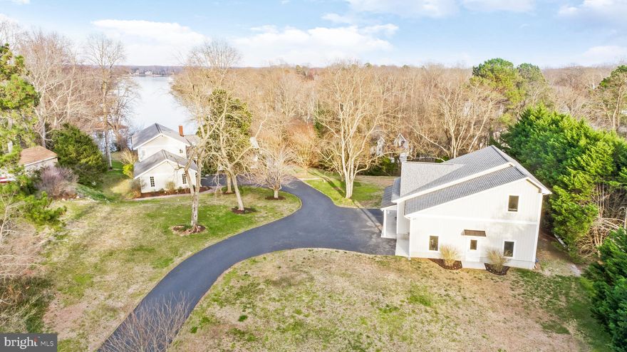 SPECTACULAR 1-MILE VIEW!! Stunningly Elegant 3700SQFT 5 Bedroom 4 Bathroom Custom Home w/ a 2-Car Attached & a 38x36 3+ Car Detached Garage which was added in 2020 (on a 1.83 Acre Lot w/ Mature Landscaping. Water views begin at the street and grow larger as you approach. As you come down the driveway you are first greeted by the oversized 38x36 Custom Detached Garage w/ 3 bays that was added in 2020. Stepping inside of the garage you quickly realize how oversized the space actually is in width, depth, & heigh with ceilings that soar to over 12'. The back upper level of the garage is home to a 12x38 storage space equipped with a material lift for easy access. A small office insulated office area w/ heat completes the detached garage. 
Driving up to the house, which underwent a Major Remodel ($450k+),  you will notice the impeccable maintenance of the exterior & landscaping. An additional 2-Car Attached Garage is perfect for your daily vehicles. The double entry front door leads you into the foyer/entryway that expands into the Great Room that is surrounded by glass allowing you to be captured by the breathtaking views immediately upon entry. This entire open entertaining space was renovated just 4 short years ago and no details were missed. The Family Room, Kitchen & Dining Area have vaulted ceilings & floor to ceiling glass that add to the grandeur of the space. The custom kitchen located to the right is worthy of an award winning magazine showcase with no details left behind. A large custom center seating island is equipped with a wine fridge & topped off w/ luxurious matte finished marble countertops. A built-in bench seat is flanked by cabinetry and adds a certain craftsman feel to the space. Quartz countertops are present on the perimeter flat surfaces while a custom cut matte marble slab creates an elegant backsplash between the centerpiece wolf range & custom metal vent hood. The corner sink area has large double windows which allow in plenty of natural light & located just to the left is a 42" built in sub zero refrigerator. The dining area is large enough to accommodate a sizeable group of guests. A large glass doorway allows access to the rear deck which wraps around to the front of the house. The left wing of the main floor is home to a living/media room pre-wired with surround sound, a main floor bedroom (currently used as an office), and a luxurious full bathroom to serve this floor. Upstairs, the primary bedroom is ample sized w/ an en-suite bath & a large balcony to take in the view. The en-suite bath has a large vanity, tile flooring, & a custom tile shower. Two additional bedrooms & a moderately sized hall bathroom complete the upper level. Downstairs, you enter the basement into a center rec area which, although large enough of its own, spills over into an even large additional rec space which is equipped w/ several storage closets, a small wet bar, & a walkout door to the back yard. The right side of the basement is set up as a sizeable studio apartment equipped with a full kitchen, a full bathroom, & its own private access to the exterior. Just under the deck is a hot tub area perfect for taking in the evening view on a cool winter night. A gentle slope leads you down to the private pier which is equipped with water, electric, & an 12,500lb boat lift. This home is an ABSOLUTE SHOW STOPPER! You need to come take a look before this home is gone! Opportunities to have views expanding 1 mile down Cuckold Creek, over 5+ garage spaces, a wonderfully private 1.83 acre lot and an exquisitely designed/renovated home do not come around very often! A very short commute to PAX River Naval Base and a modest commute to Washington, DC make this home the perfect fit for those looking to live here full time or to take full advantage of waterfront living as a second home! Pass this one up and you will find yourself wishing you had all this home provided!!!