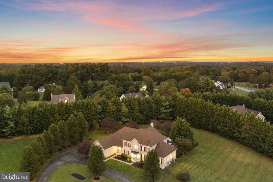 Custom Luxury Estate in Pindell Chase, Fulton
Experience unparalleled luxury and privacy on this stunning 1.29-acre estate in prestigious Pindell Chase. This custom Toll Brothers home offers complete seclusion with majestic 40-foot Leland Cypress trees providing natural privacy on three sides. Over 100 red and white plum trees create a breathtaking entrance along the cul-de-sac driveway. The property is located in the River Hill High School district.

*Masterfully Crafted Interior
Step into this magnificent 7,500+ square foot home through an impressive 2-story foyer featuring a granite emblem centerpiece surrounded by white marble flooring. Superior craftsmanship is evident throughout with custom crown molding and designer paint. The sun-filled conservatory boasts opulent marble floors, while the mahogany-trimmed office provides sophisticated workspace with built-in cabinetry.
The chef's kitchen features premium stainless steel appliances and oversized island, with convenient mudroom entry connecting elegant spaces with functional design.

*Luxurious Owner's Retreat
The owner's suite serves as a private sanctuary with a personal balcony overlooking the serene backyard. Entertainment features include a 40-inch television with surround sound and cozy sitting room with gas fireplace. The spa-inspired master bathroom offers a soaking tub, oversized shower, and custom dual closets.

*Entertainment-Ready Lower Level
The fully finished 2,400 square foot basement features an additional bedroom, a full bathroom, and a bonus room. Entertainment amenities include a wet bar, private gym, pool table, and TV lounge area perfect for gatherings.

*Resort-Style Outdoor Living
Recent pool renovations totaling over $50,000 include new pool decking, resurfacing, tile, and coping. A 7-person hot tub and large deck extend entertainment options. The property includes a basketball court and can accommodate 50-60 guests for both intimate gatherings and grand celebrations.

*Prime Location and Modern Upgrades
Other upgrades include new upper level HVAC, water heater, well pump, and water softening/filtration system. Located just one mile from Maple Lawn's shops and restaurants. This exceptional estate offers the perfect combination of luxury, privacy, and convenience.