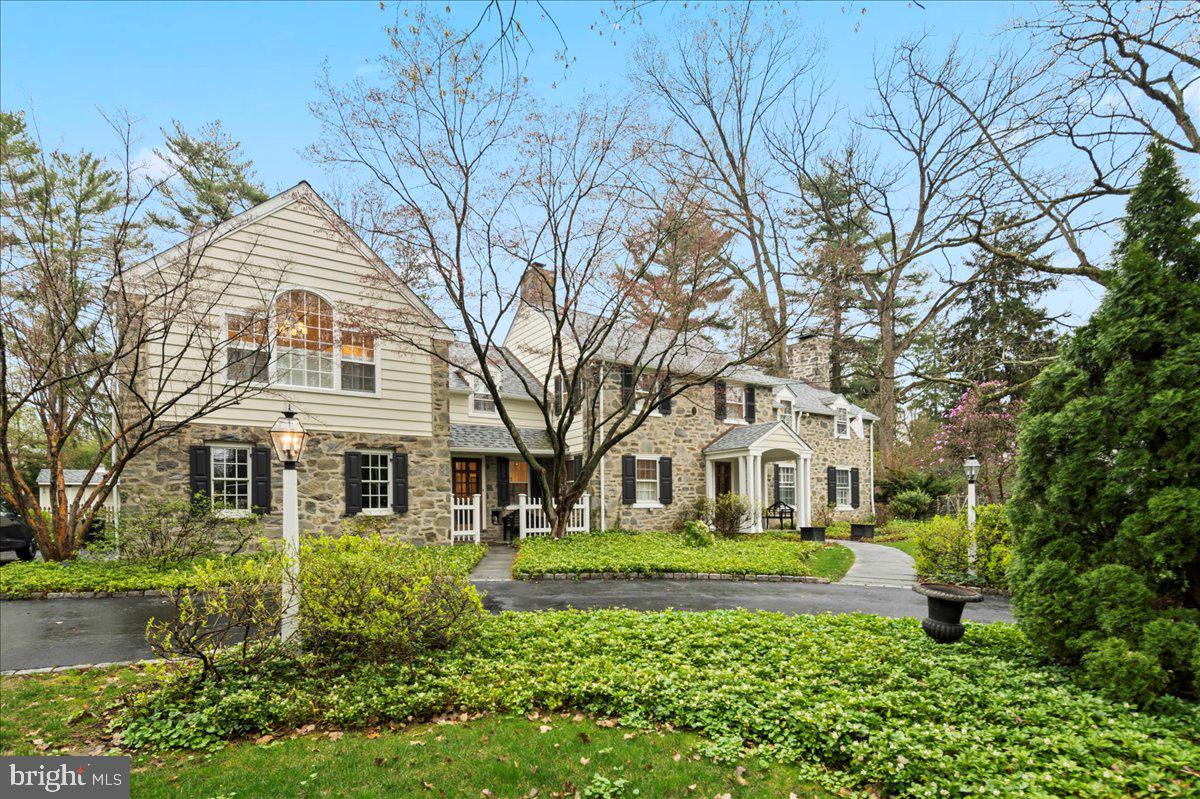 A Refined Stone Colonial in the Heart of Bryn Mawr
Set on a picturesque ¾-acre parcel in coveted Bryn Mawr, this timeless five-bedroom stone Colonial welcomes with understated elegance and extraordinary detail throughout. A flagstone path leads to the front door, inviting you into a home where every element has been thoughtfully considered and impeccably maintained.
The foyer opens to a gracious living room with large windows, a gas fireplace, and a French door that extends the living space onto a bluestone terrace—complete with an awning for shaded afternoon gatherings. Across the foyer, a formal dining room echoes the same effortless flow, with its own French door opening to the terrace, creating a seamless connection between indoor and outdoor entertaining.
At the heart of the home lies a custom Wood-Mode kitchen—a beautifully designed space with sleek quartz countertops, a professional Viking gas range, ample storage including a deep walk-in pantry, and both island seating and a built-in banquette for casual dining. Glass-front cabinetry provides a stylish showcase for your finest china and glassware.
Adjoining the kitchen is a dramatic family room with soaring ceilings, a second gas fireplace set in a striking stone surround, and tall windows that frame views of the lush gardens. French doors open to the pool, terrace, and a charming storage cottage, enhancing the home’s relaxed indoor-outdoor lifestyle.
A newly renovated laundry room—finished to such a high standard it hardly feels like a chore—features quartz counters, abundant storage, and designer finishes. A mudroom and two elegant half baths complete the main level.
The lower level is a destination of its own—chic and inviting with Gucci wall coverings, offering expansive recreation space, a full gym, game area, and easy access to mechanicals.
Upstairs, five bedrooms and three full baths await, accessed via front or rear staircases. The serene primary suite enjoys its own dedicated HVAC zone and features two walk-in closets, a third gas fireplace, and a luxurious white quartz bath with an under-window soaking tub, seated shower, dual vanities, and a private water closet. Of the additional bedrooms, three share a recently renovated hall bath featuring radiant heated floors and large-format tile, while a fourth bedroom offers an en suite bath and a spacious dressing area.
Throughout the home, a calm palette of soft neutrals and exceptional craftsmanship provide a cohesive sense of refinement. The interior aesthetic is sophisticated yet relaxed, the result of careful selections and the skilled hands of a three-generation team of expert craftsmen.
Additional amenities include a 3-car garage, whole-house generator, and recently updated pool equipment.
This is a home of quiet distinction—humble in its exterior presentation, yet effortlessly chic and welcoming inside. A true Bryn Mawr gem.