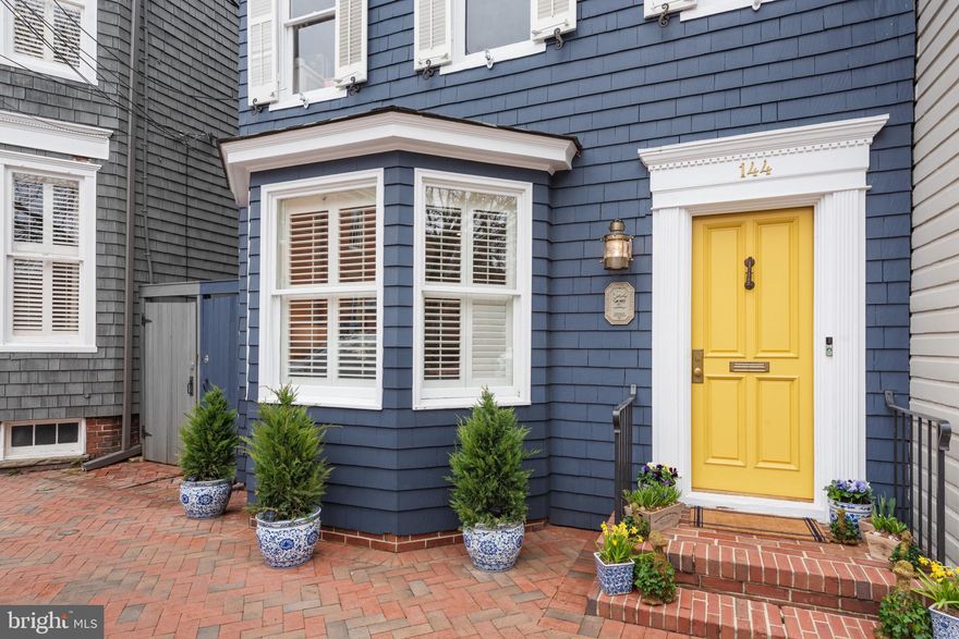 Timeless Elegance in the Heart of Historic Annapolis.  Tucked away on one of Annapolis’ most charming streets, this circa-1900 home blends historic character with thoughtful, high-end renovations. Painted deep navy cedar shingles with crisp white trim, this unique home sits gracefully along a brick-paved sidewalk, just steps from the waterfront, the U.S. Naval Academy, and downtown’s best restaurants, coffee shops, and boutiques.  

Inside, a sense of history lingers with colonial heart pine hardwood floors, original brickwork, and detailed millwork, while modern updates bring effortless style. The family room, with its bay window and plantation shutters, offers a bright, inviting space. Beyond it, the dining room, anchored by custom built-ins that discreetly house a wet bar, wine and beverage refrigerators, and an ice maker is ideal for entertaining.  The gourmet kitchen, a showpiece, balancing warmth and sophistication with marble counters, brass and leather hardware, and a custom hood set into an old brick chimney—now framing a Wolf gas range. A paneled Sub-Zero refrigerator and Bosch dishwasher blend seamlessly into the cabinetry. French doors open to a large private brick patio, where lush landscaping creates a peaceful retreat with plenty of room to entertain or relax with close friends and family.  

The primary suite on the second floor features an en-suite bath, with a dual sink, a make up vanity and a large walk in shower. The laundry room is also conveniently located on this level, along with a second full bath and  bedroom. The third floor offers two additional bedrooms connected by a Jack-and-Jill bath.  

Registered in both the Annapolis and National Historic Districts, this home is a rare blend of period charm and modern ease—a place where history meets everyday comfort in the most effortless way.